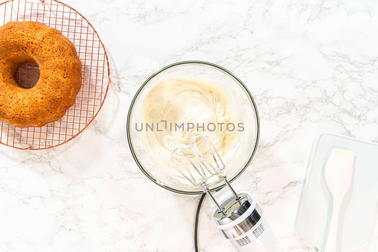 In a large mixing bowl, the ingredients are expertly mixed to create a delectable cream cheese buttercream for the Carrot Bundt Cake.
