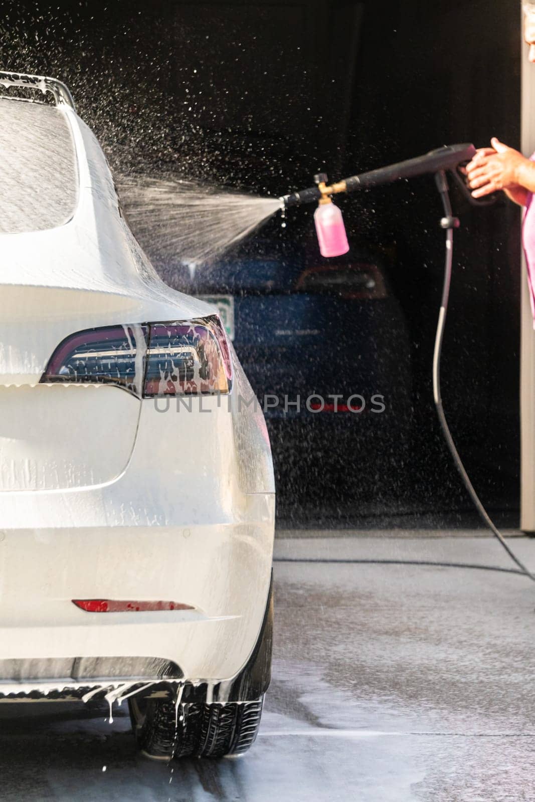 Efficiently cleaning an electric car in the comfort of a suburban driveway, combining eco-consciousness with practicality.