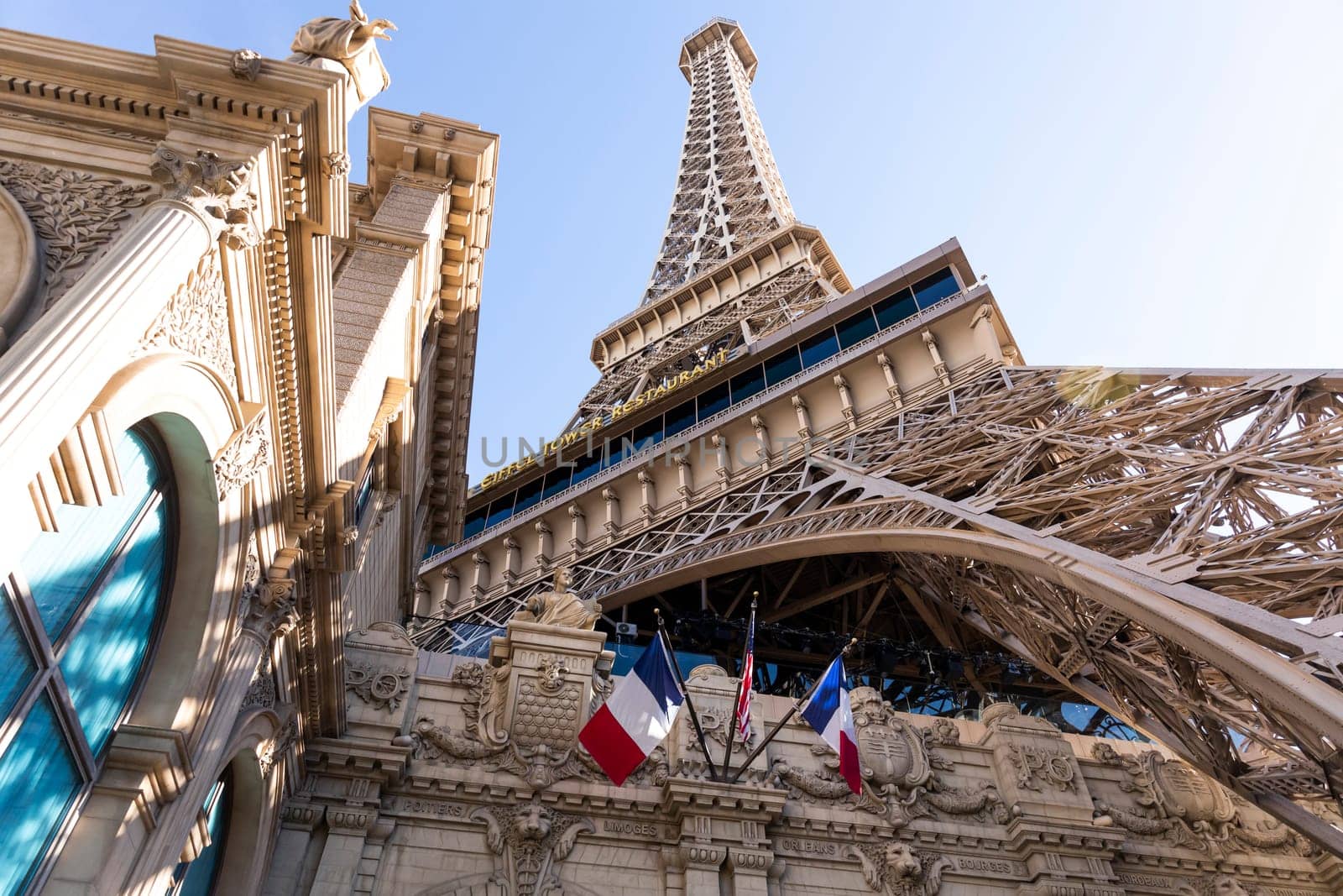 Eiffel Tower, Paris Las Vegas Hotel. Low Angle View. Blue Sunny Sky On Background. Tricolor Flag Of France And The USA. Copy Space, Horizontal Plane. Las Vegas, Nevada, USA: December, 27 2024.