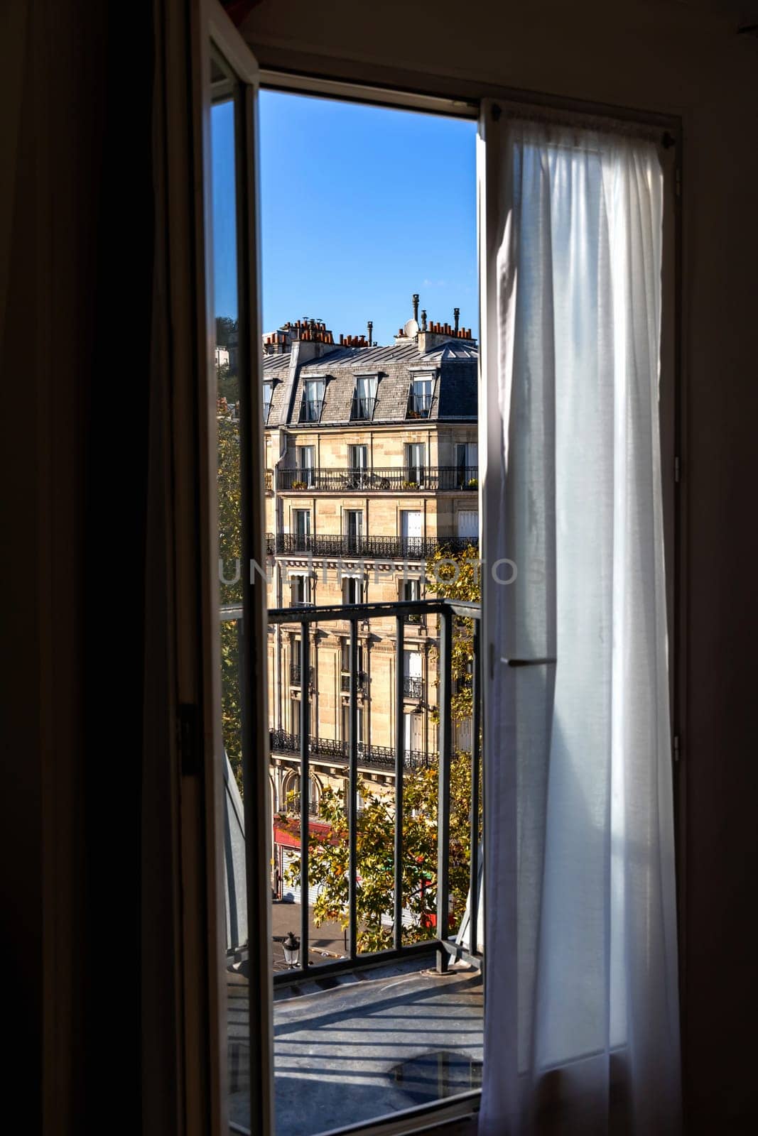 Open window overlooking the city with old buildings. Paris, France - October 24, 2024