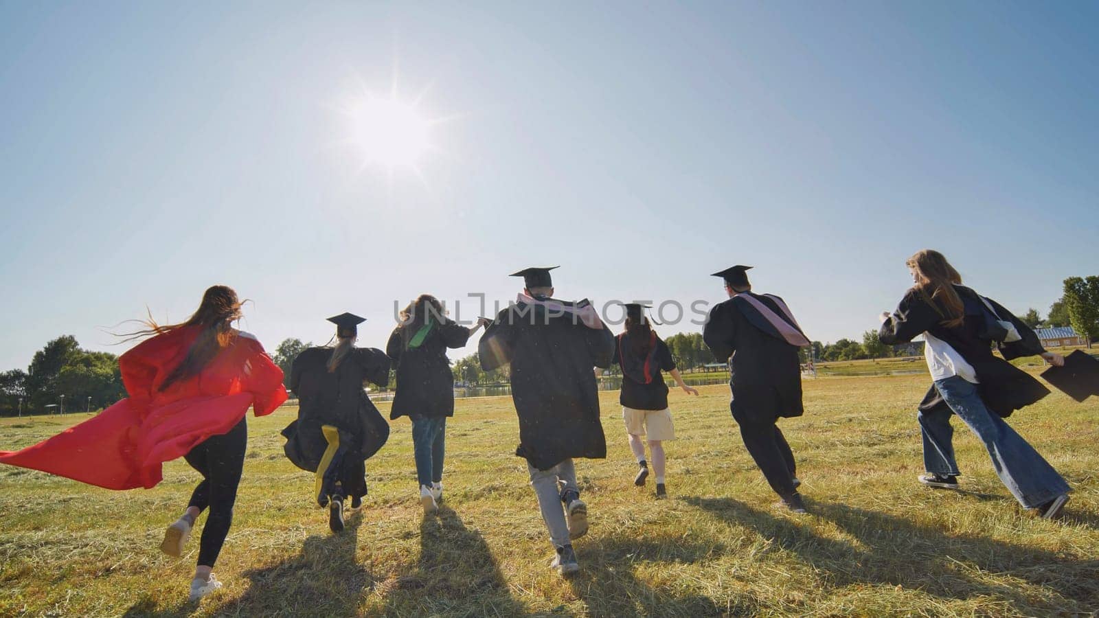 Happy graduates run in and take off their robes. The concept of graduation