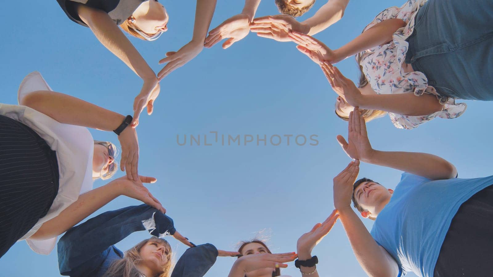 School friends make a big circle with their hands. by DovidPro