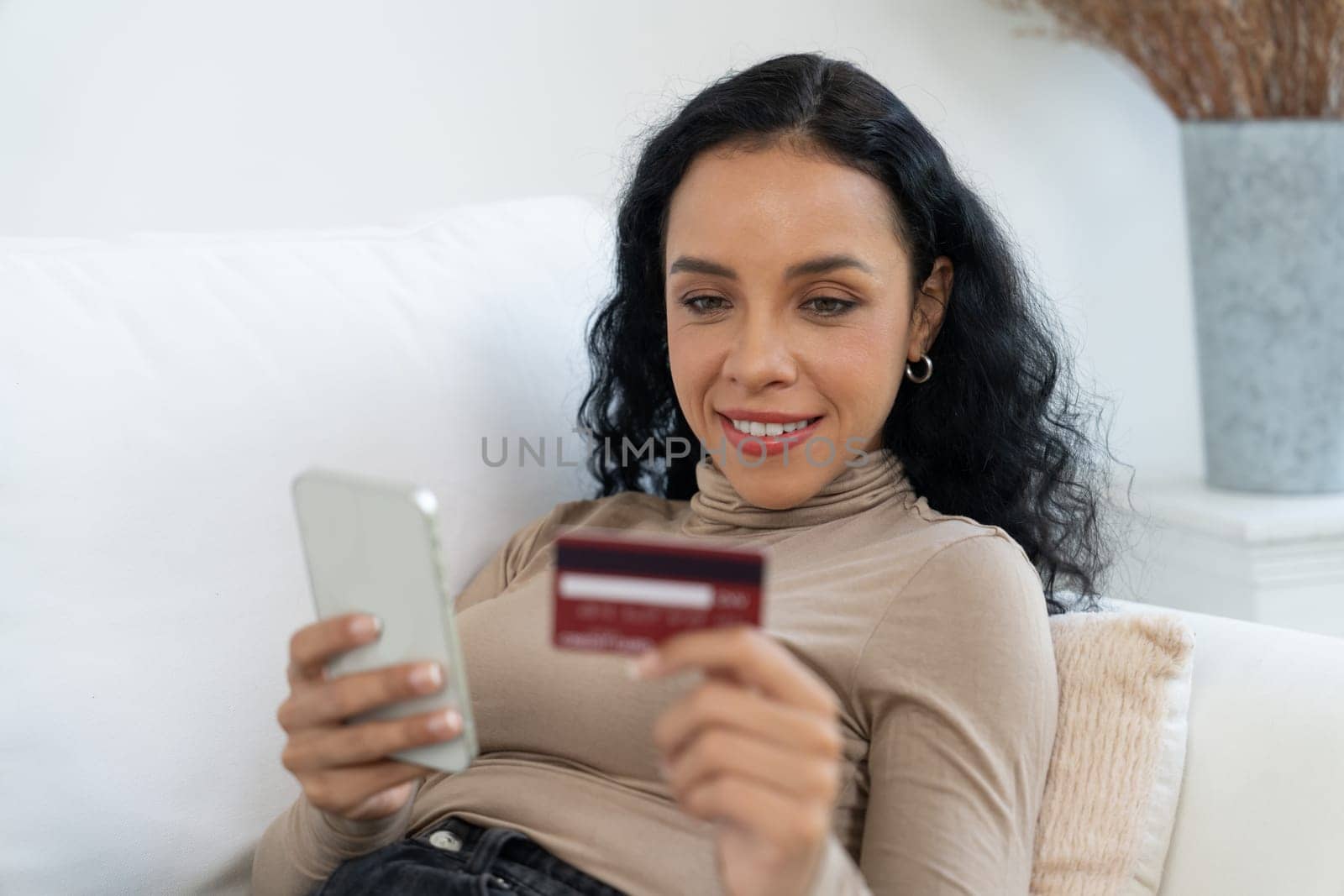 Young happy woman buy product by online shopping at home while ordering items from the internet with credit card online payment system protected by crucial cyber security from online store platform