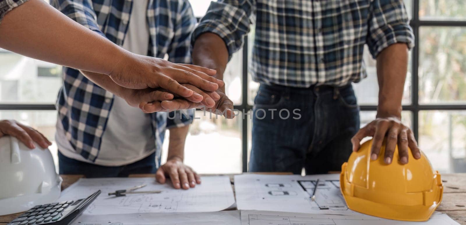 A team of engineers who successfully planned work on a modern home construction project shook hands and congratulated the team on their success..