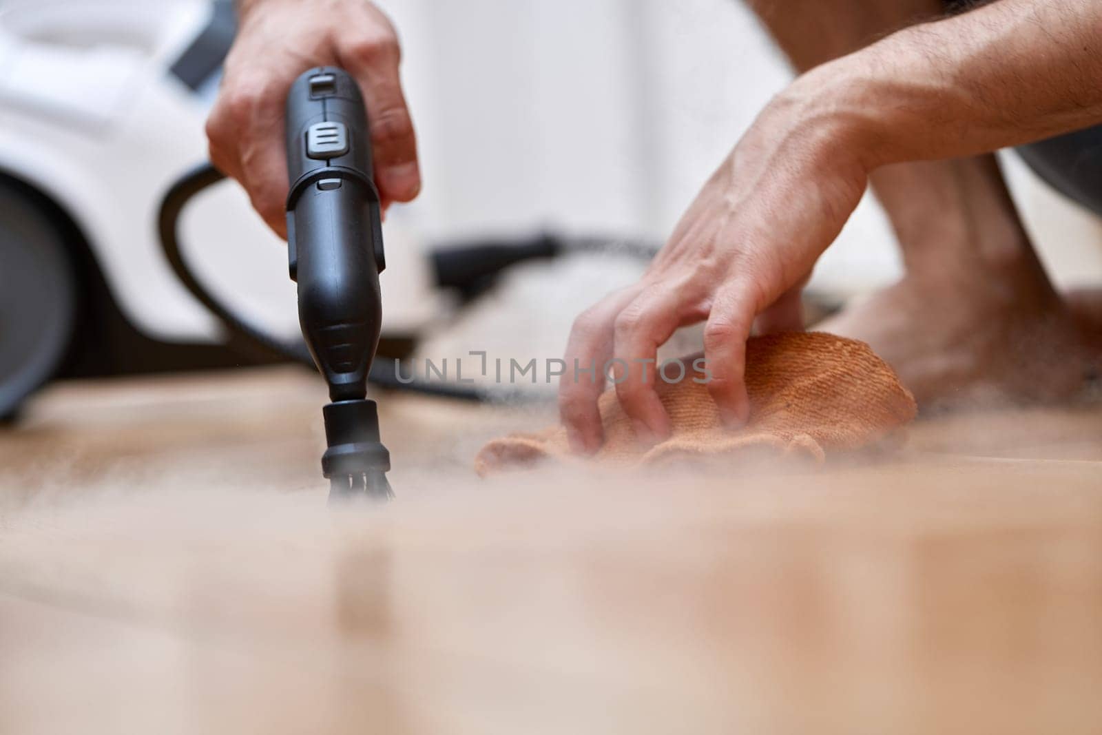 male hand with professional cleaning steam generator cleaning tiled floor, home disinfection