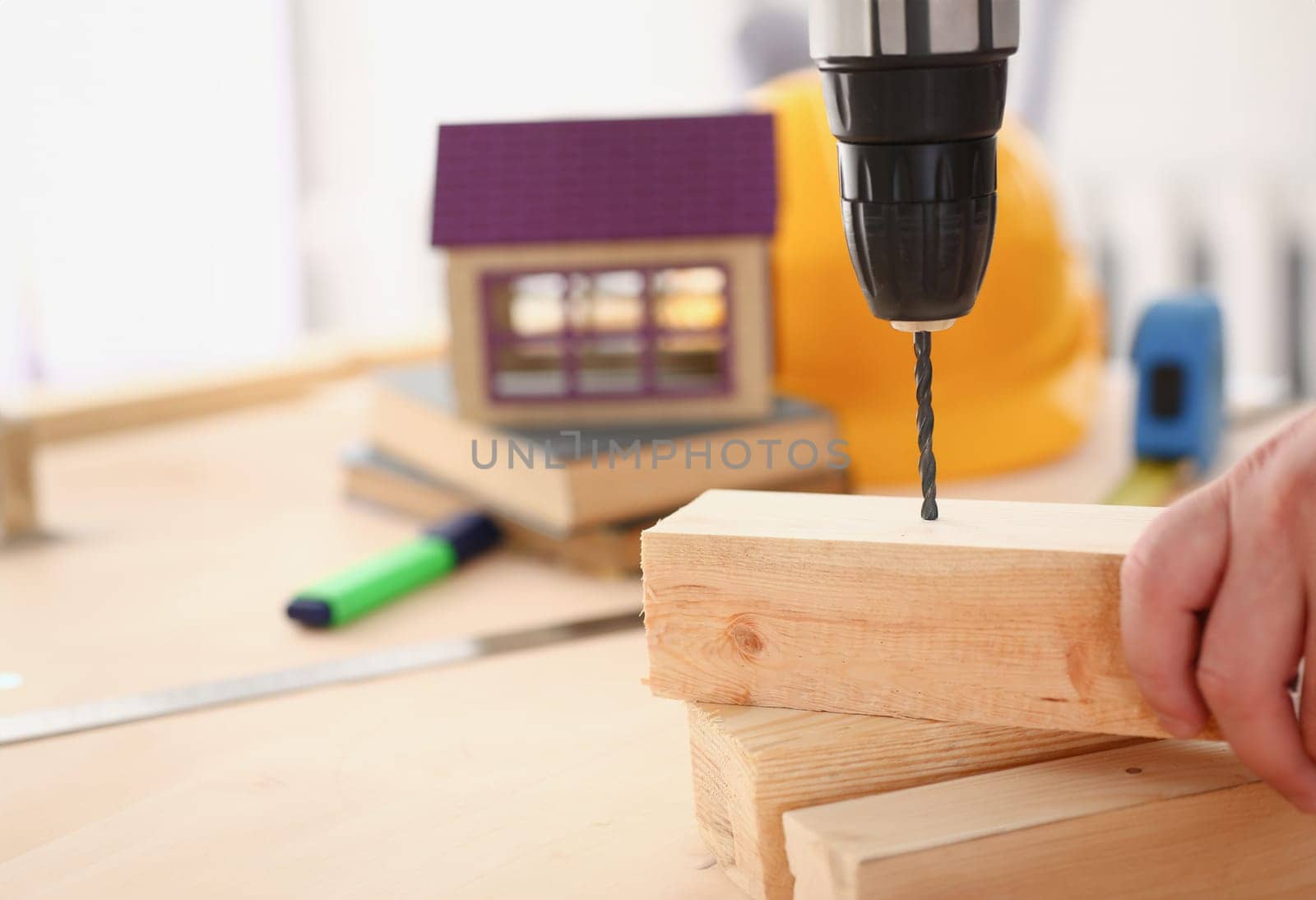 Arms of worker using electric drill by kuprevich