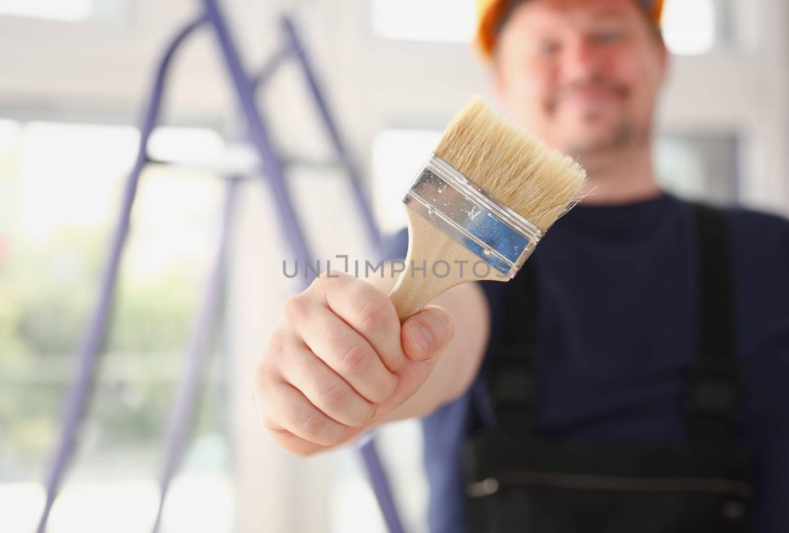 Arm of smiling worker hold brush closeup by kuprevich