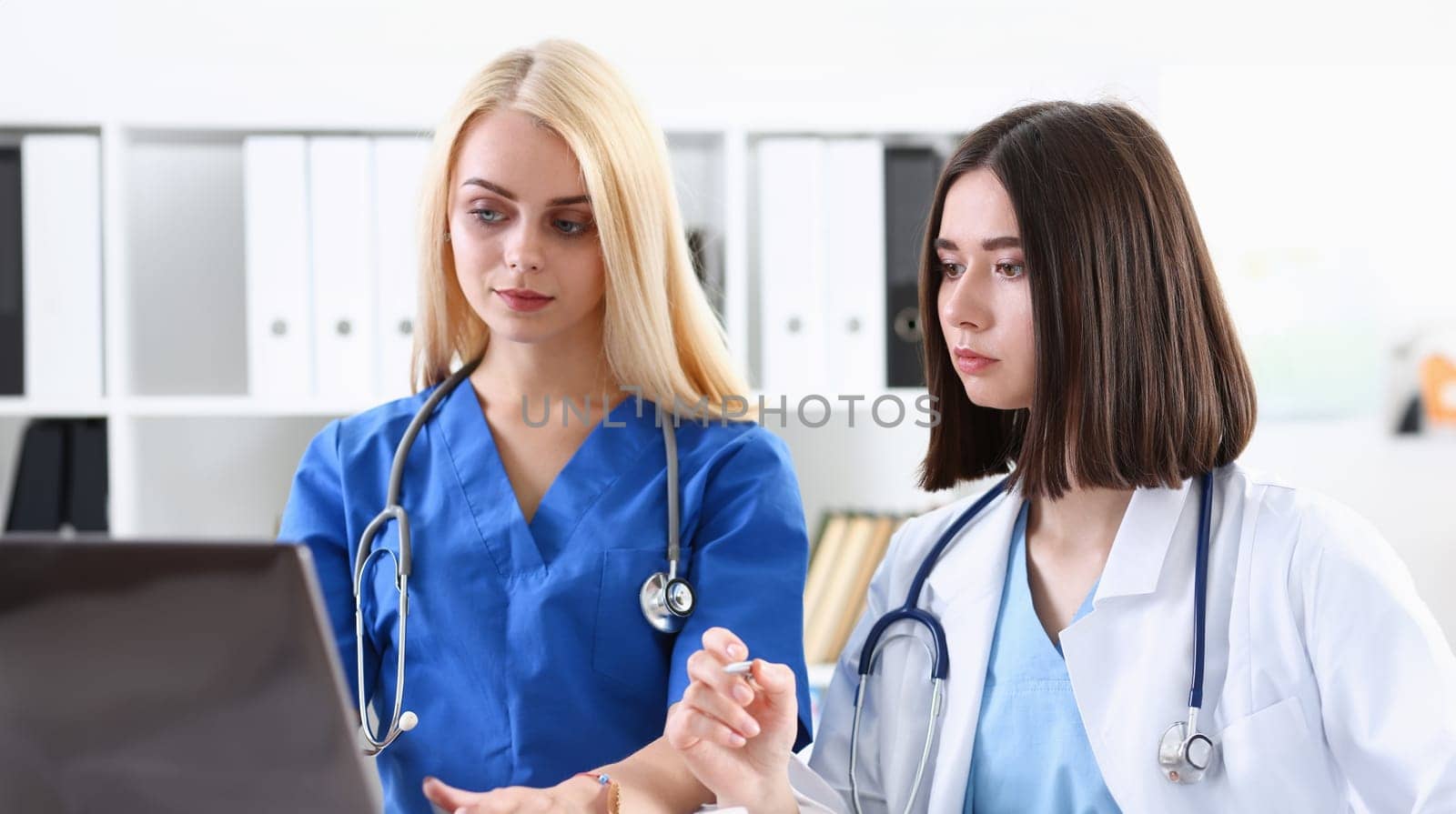 Group of doctors using laptop pc sitting in office. General practitioner portrait telemedicine therapeutist professional conversation modern communication remote cure expert assistance concept