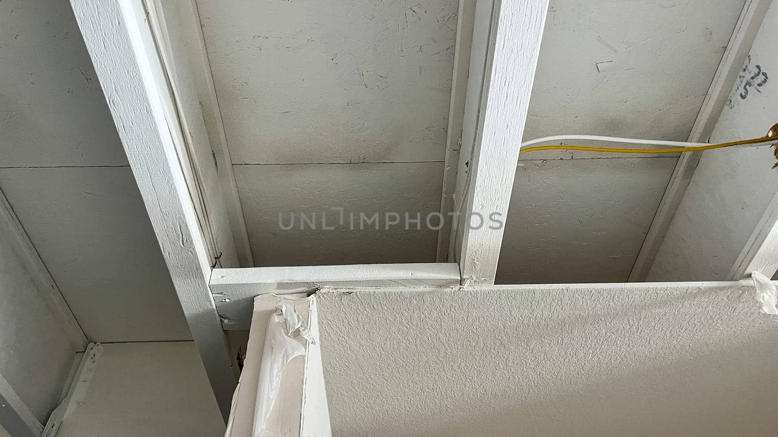 Castle Pines, Colorado USA - January 18, 2023-Close-up of exposed ceiling joists and electrical wiring in the unfinished basement of a newly constructed single-family home. The image captures the structural framework and early electrical installation, showcasing the construction progress.