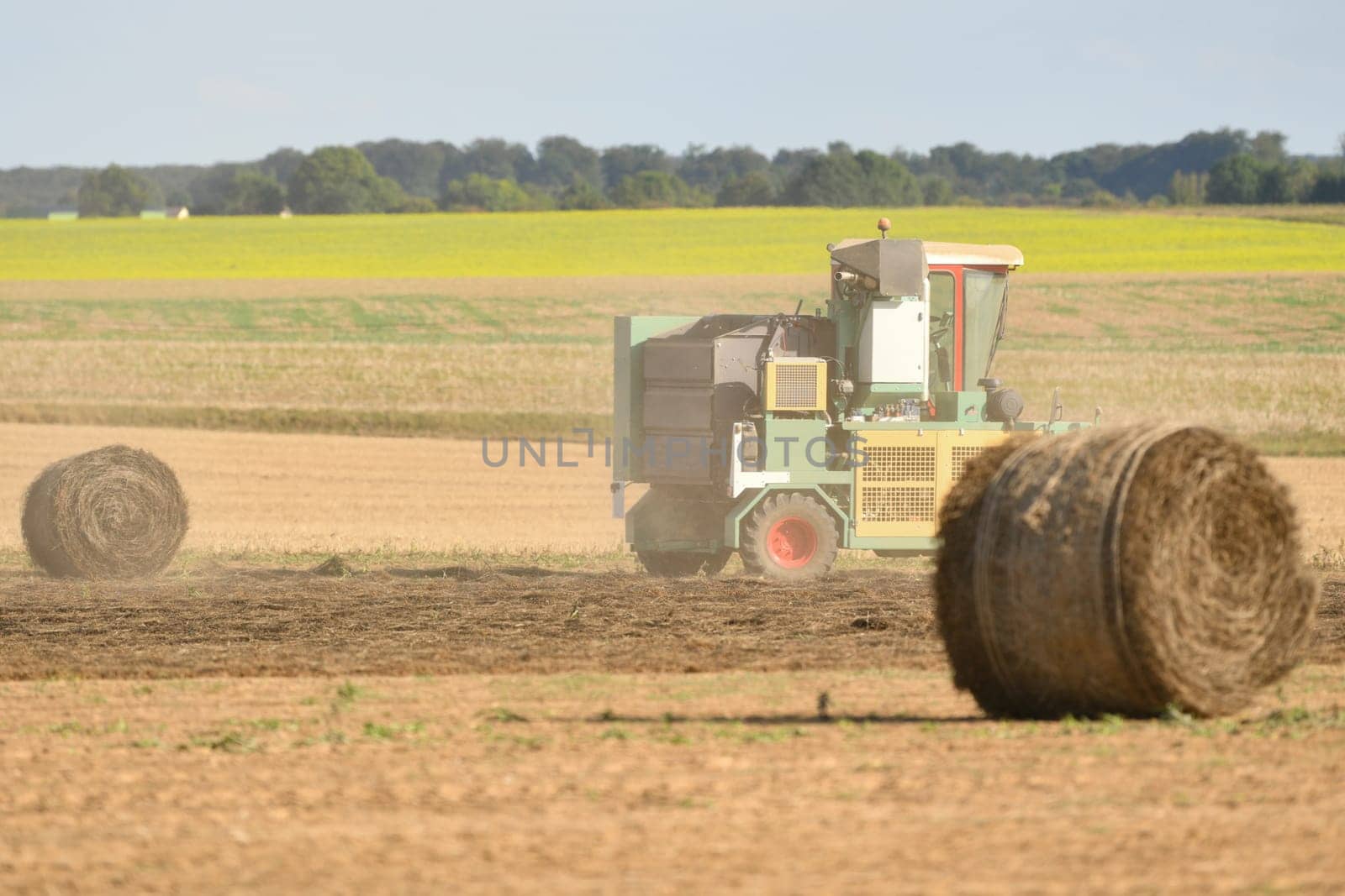 Tractor cleans the field with flax and makes bales