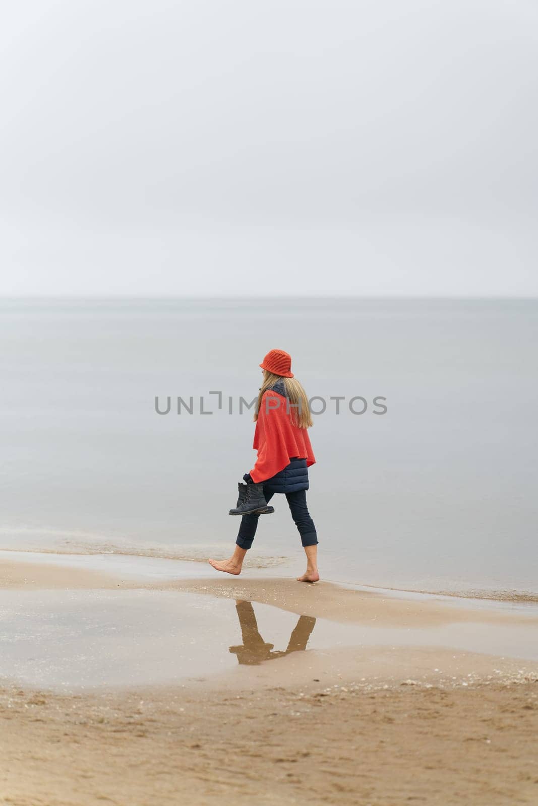 Swinoujscie , Poland – December 26, 2024: Fashionably dressed woman walking on the beach of Swinoujscie on the Polish Baltic Sea coast