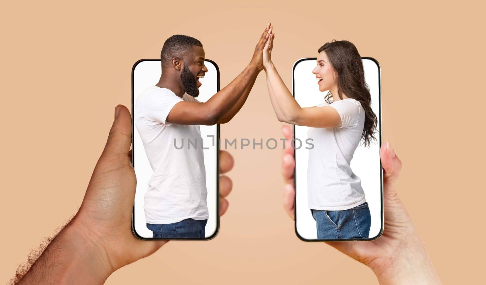 A couple engages with each other using smartphones, their hands touching through screens, showcasing modern communication in their relationship.