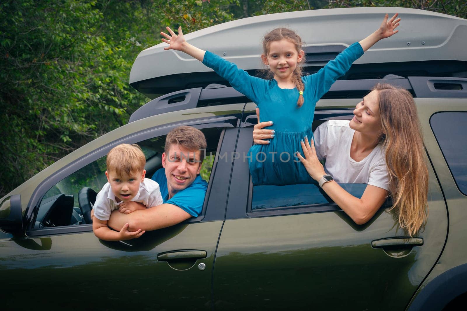A joyful and cheerful family of four enjoying a funfilled outdoor trip together in their spacious SUV