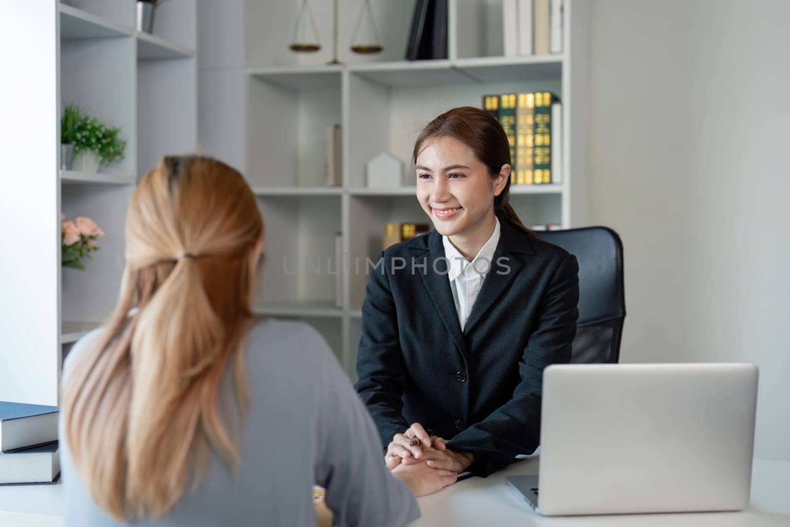 A cheerful lawyer engages with a client, discussing contract options and legal advice in a sleek office, highlighting professionalism and trust in legal services.