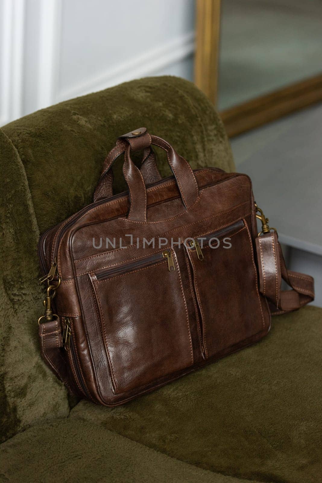 Brown leather briefcase on chair, close up.