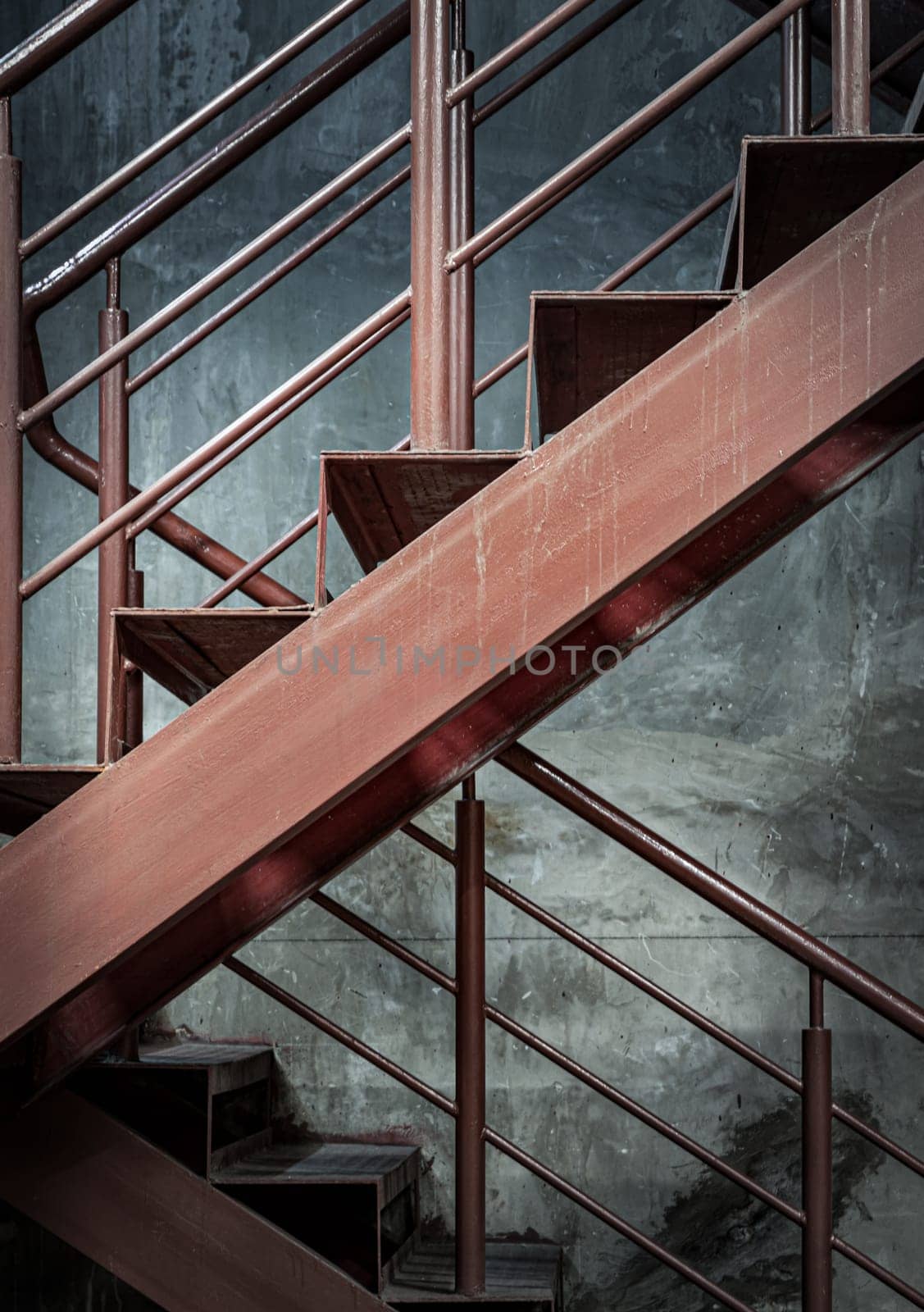 Vertical view of Old Steel ladder with handrails with concrete wall in the background. Side view of Metal steps, Dark tone, Copy space, Selective Focus.