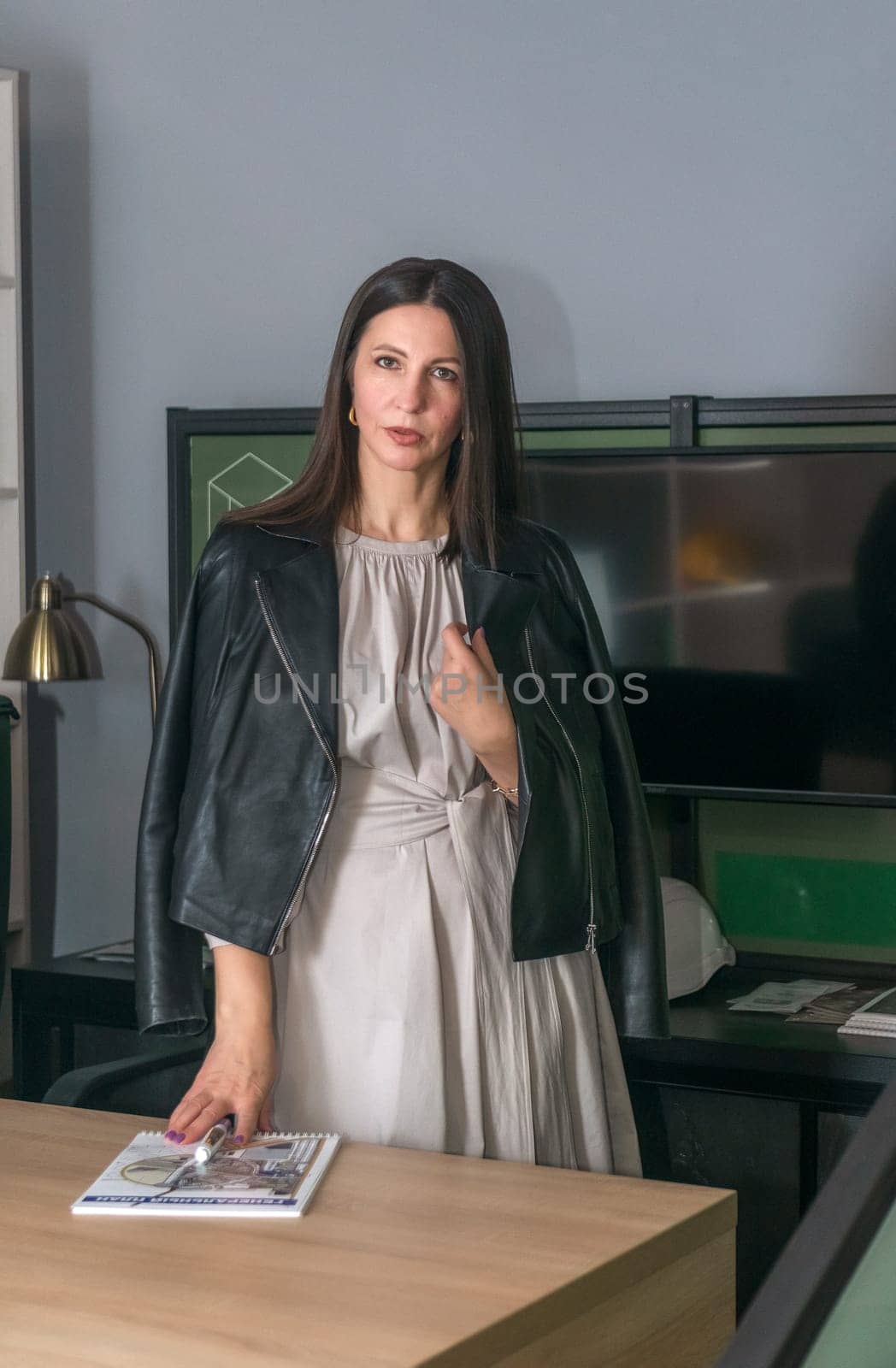Portrait of mature business woman with arms crossed looking at camera.She is holding a white construction helmet Happy smiling mid businesswoman standing in office with copy space.