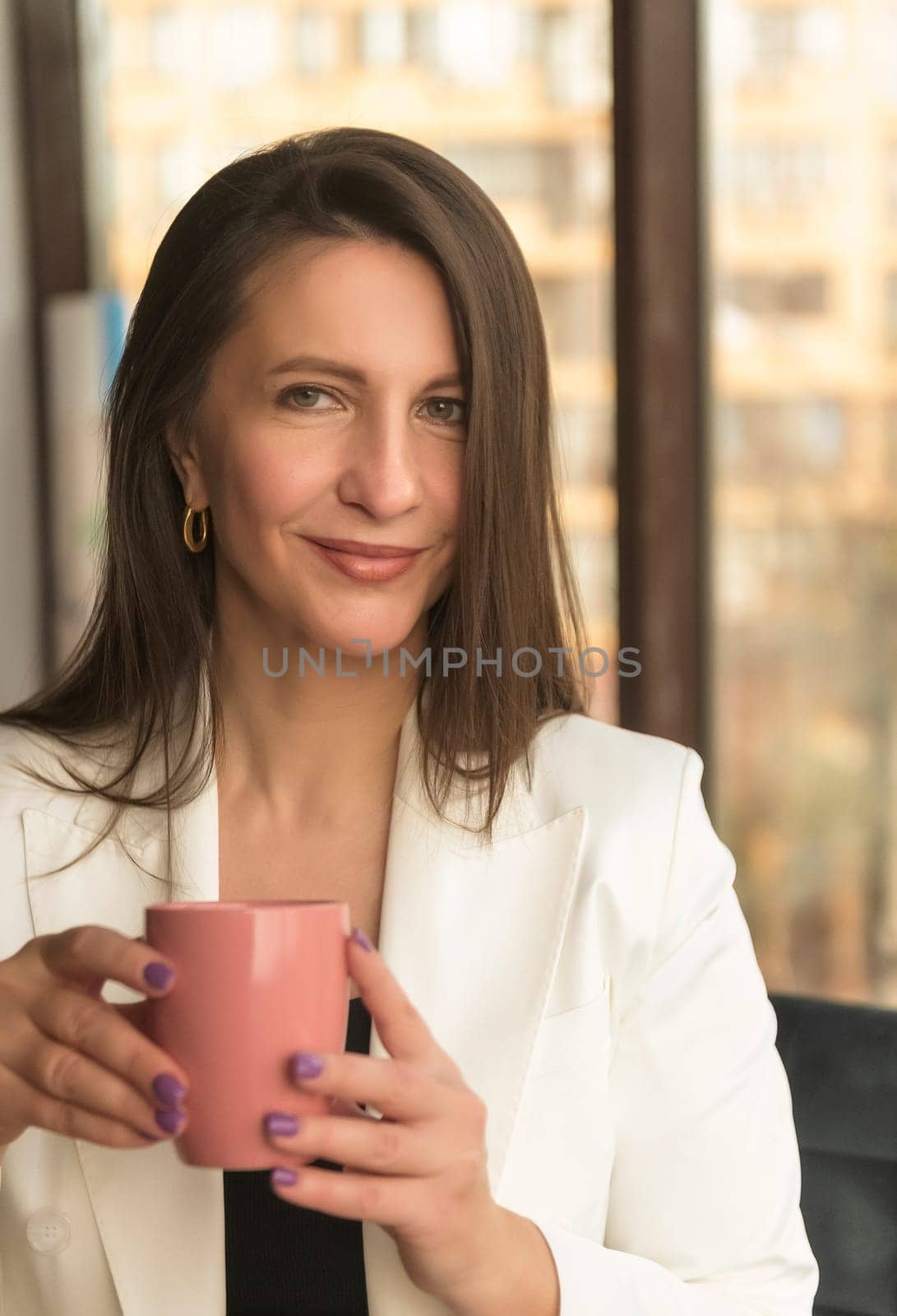 Portrait of mature business woman with arms crossed looking at camera.She is holding a white construction helmet Happy smiling mid businesswoman standing in office with copy space.