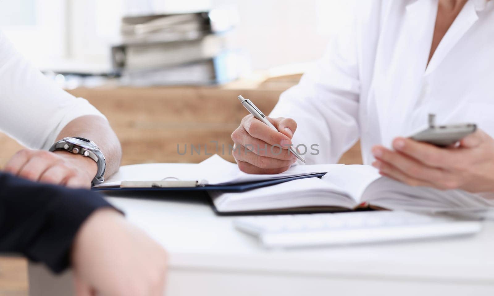 Concerned handsome doctor communicate with patient holding silver pen and showing pad. Physical agreement signature disease prevention consent sign 911 prescribe remedy healthy lifestyle concept