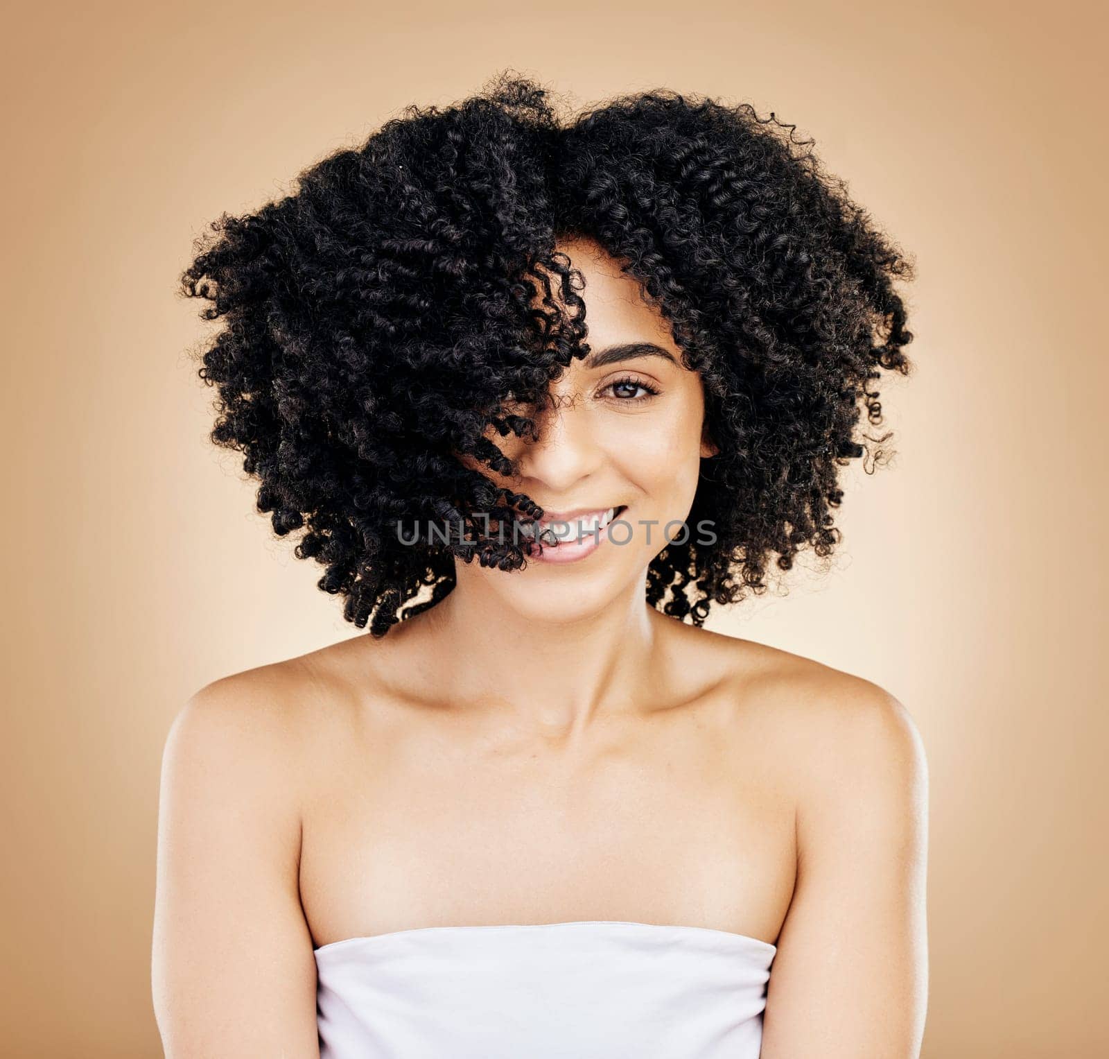 Hair, curls and portrait of woman, beauty and treatment for shine, cosmetic care and smile on studio background. Wellness, haircare and growth with strong texture and shake locks, volume and afro by YuriArcurs