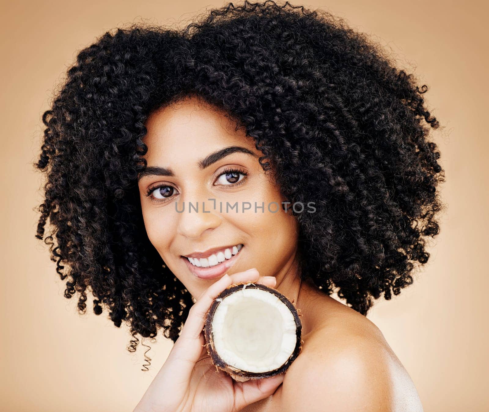 Woman, portrait and hair, coconut with shine and beauty, organic salon treatment for strong texture on studio background. Face, skin and natural cosmetic product for growth with haircare and fruit by YuriArcurs