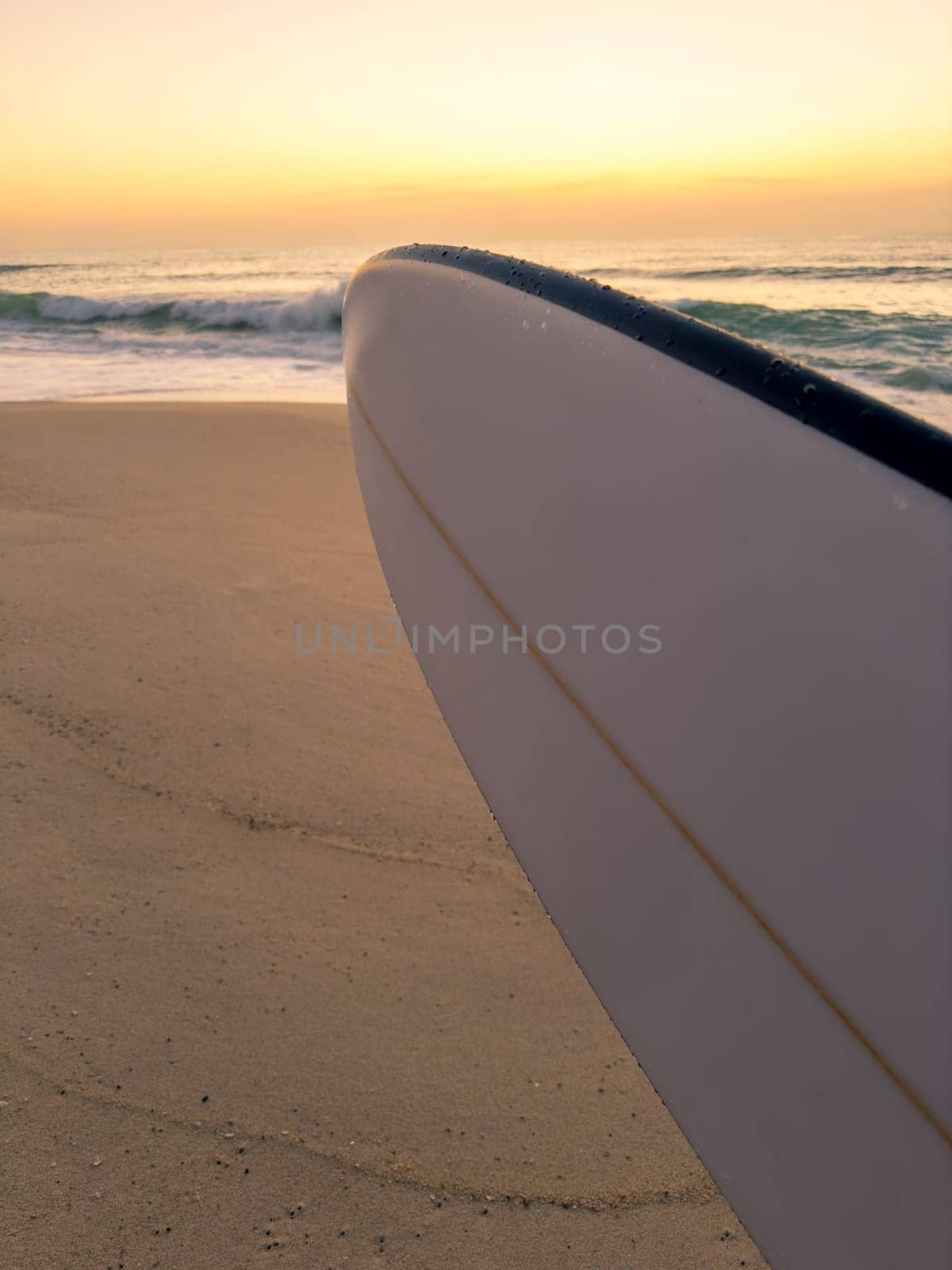 Surfboard nose shape with beach sunset on the background.