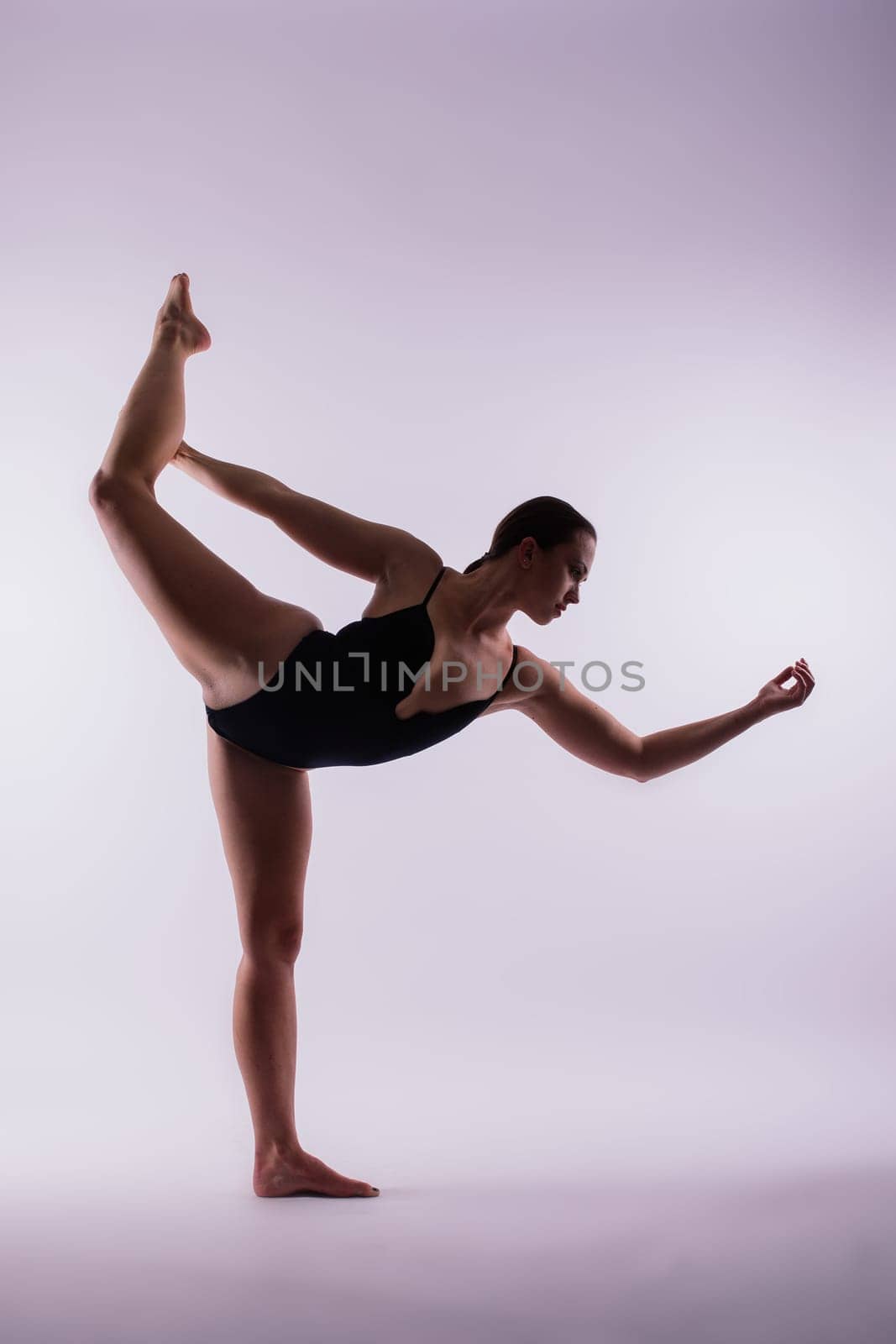 Young beautiful yoga female posing on studio background