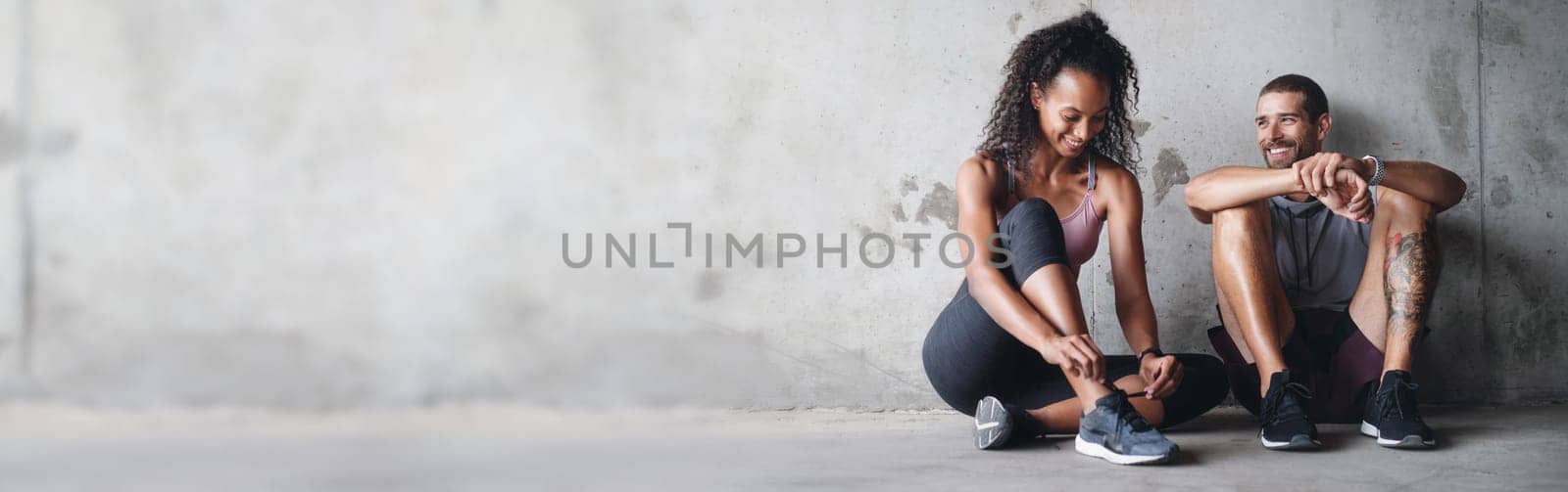 Couple, fitness and happy by banner on break, active and health or wellness. Positive people, smile and exercise by training, gym and space on gray background, performance and cardio workout at wall.