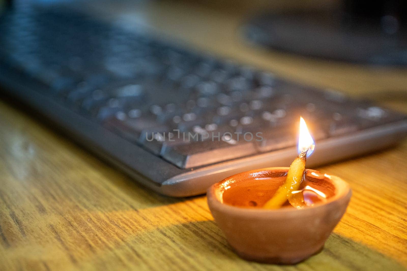 Earthenware diya lamp placed near keyboard shoiwng growth of IT software business this diwali by Shalinimathur