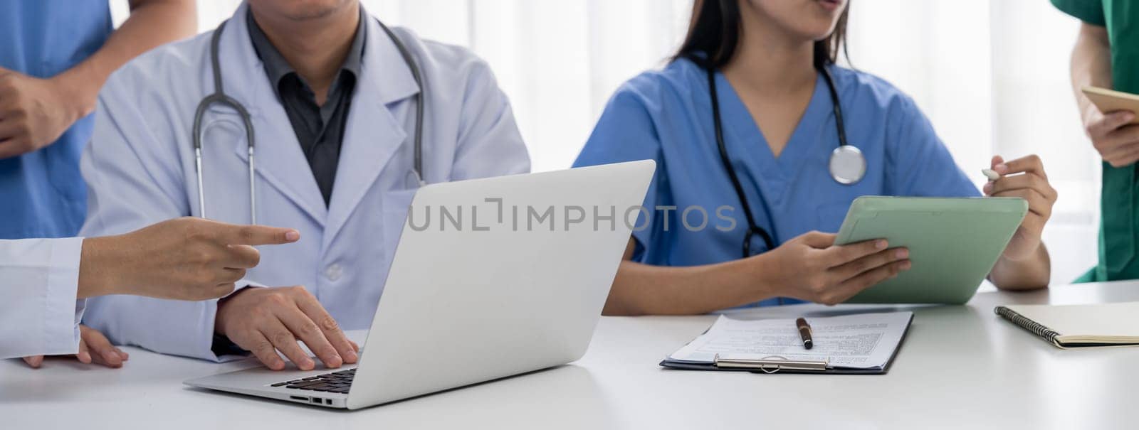 Professional various team of medical working and planning medical treatment at hospital table together. Teamwork lead to successful illness and sickness treatment. Panorama Rigid