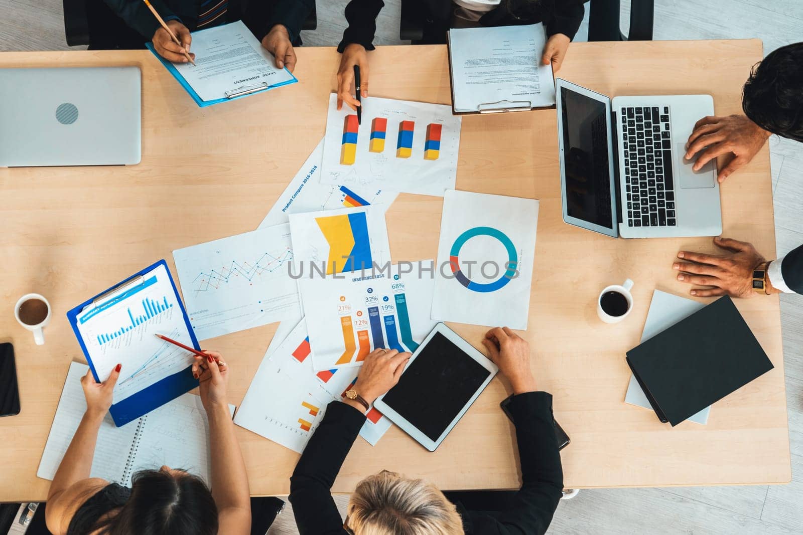 Business people group meeting shot from top view in office . Profession businesswomen, businessmen and office workers working in team conference with project planning document on meeting table . Jivy