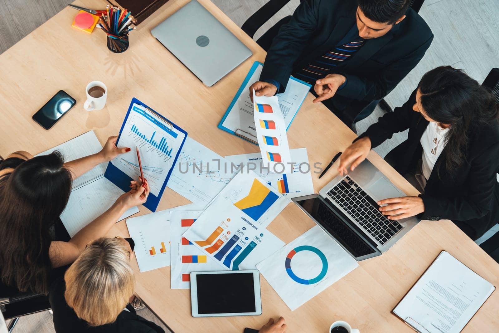 Business people group meeting shot from top view in office . Profession businesswomen, businessmen and office workers working in team conference with project planning document on meeting table . Jivy