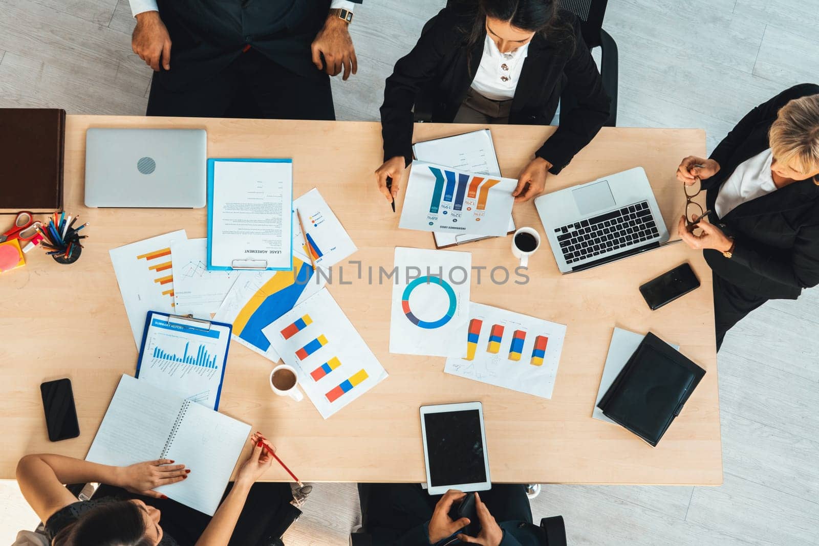 Business people group meeting shot from top view in office . Profession businesswomen, businessmen and office workers working in team conference with project planning document on meeting table . Jivy