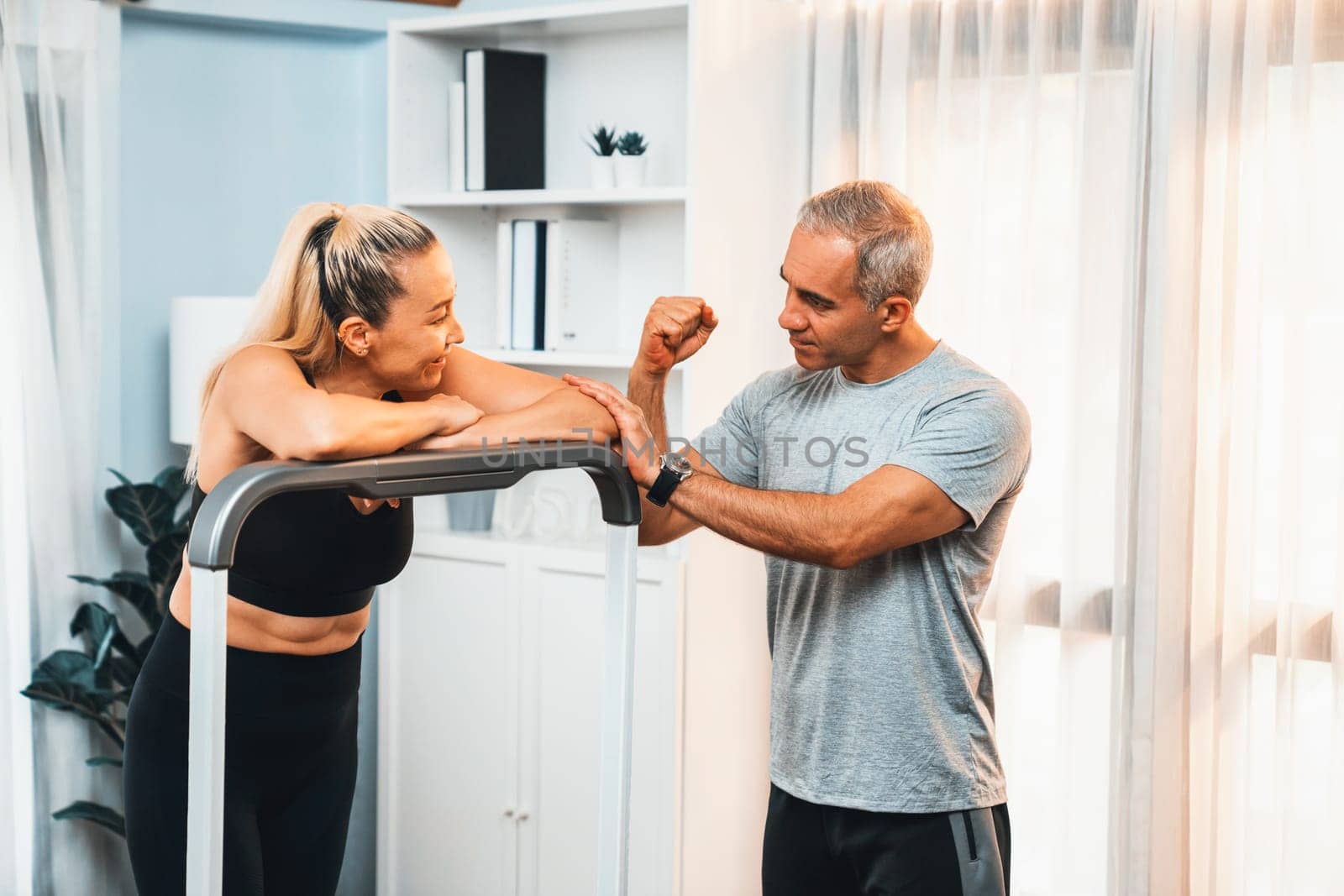 Active senior couple running on tread running machine at home together as fitness healthy lifestyle and body care after retirement for pensioner. Clout