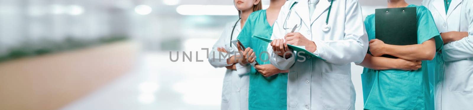 Confident medical staff team with doctor nurse and healthcare specialist professions people in blurry hospital corridor background. Medical and healthcare community in panoramic banner. Neoteric