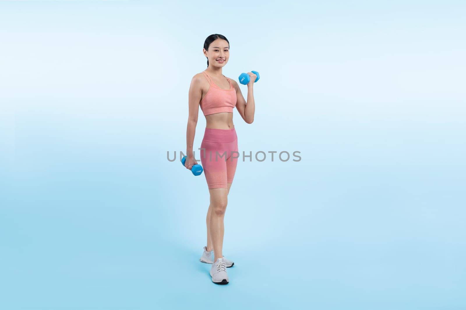 Vigorous energetic woman doing yoga with dumbbell weight exercise. by biancoblue