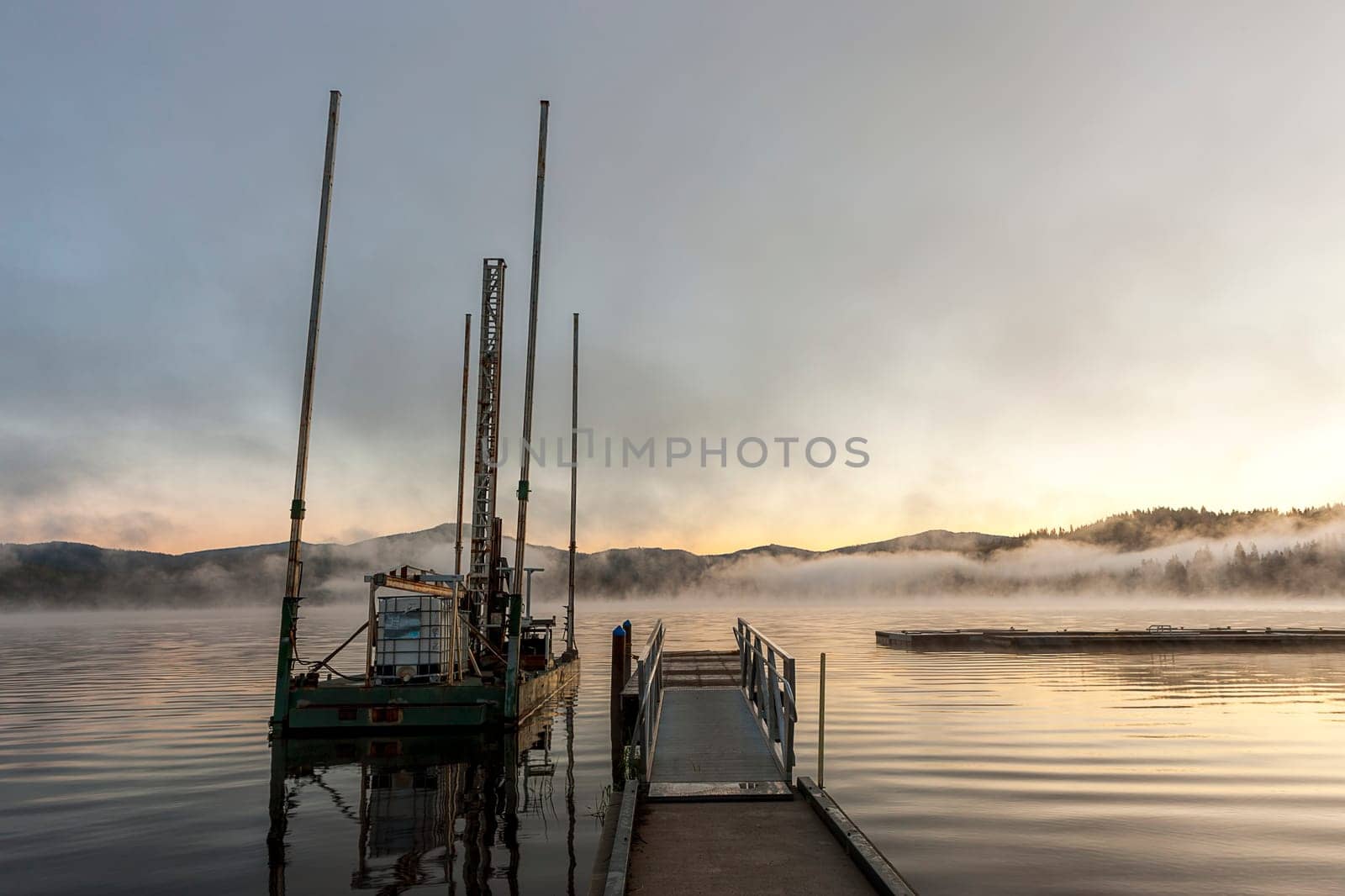 A small barge by a dock at sunrise in Hauser Lake, Idaho.