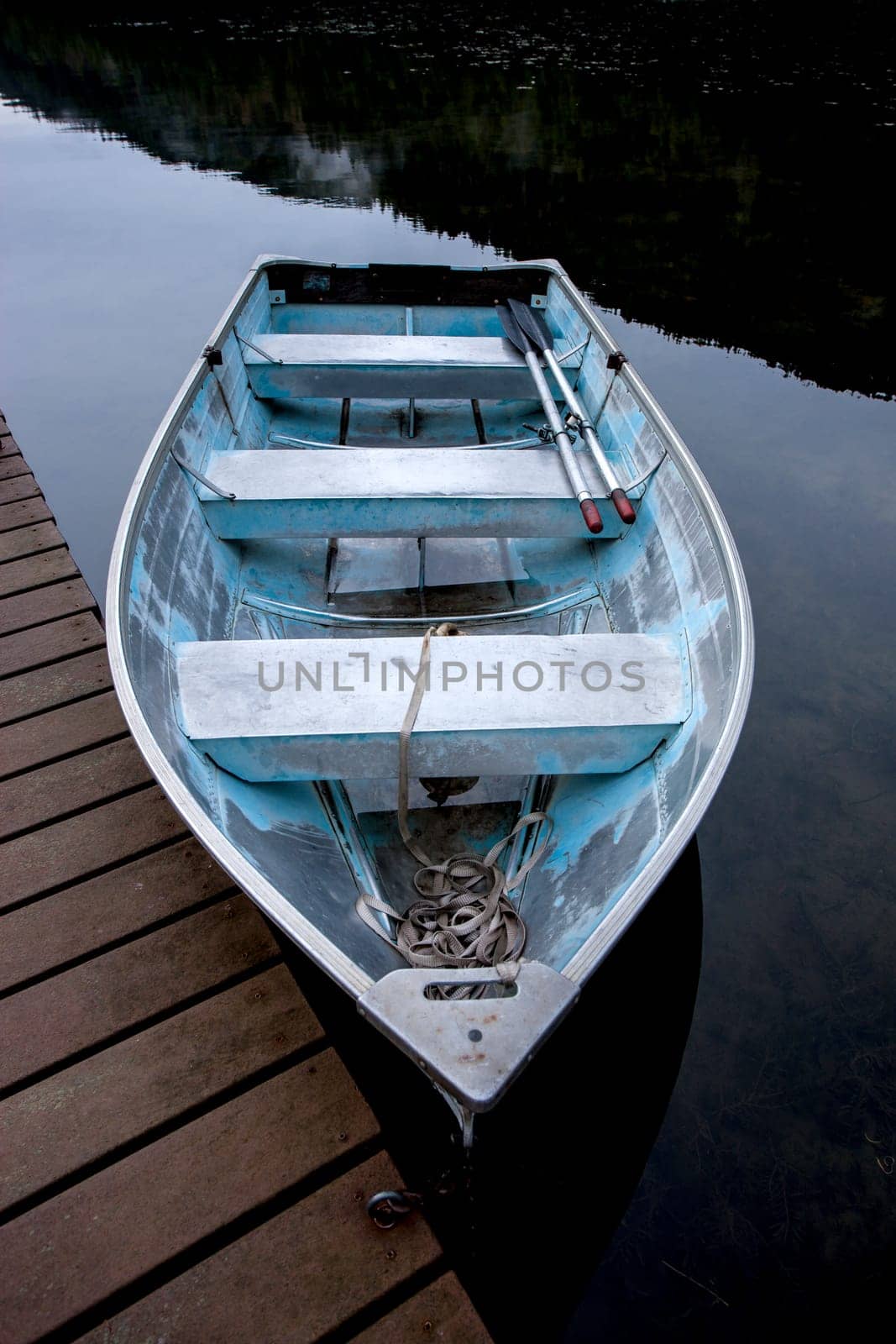 A close up of a small rowboat tied to a wooden dock near Sagle, Idaho.