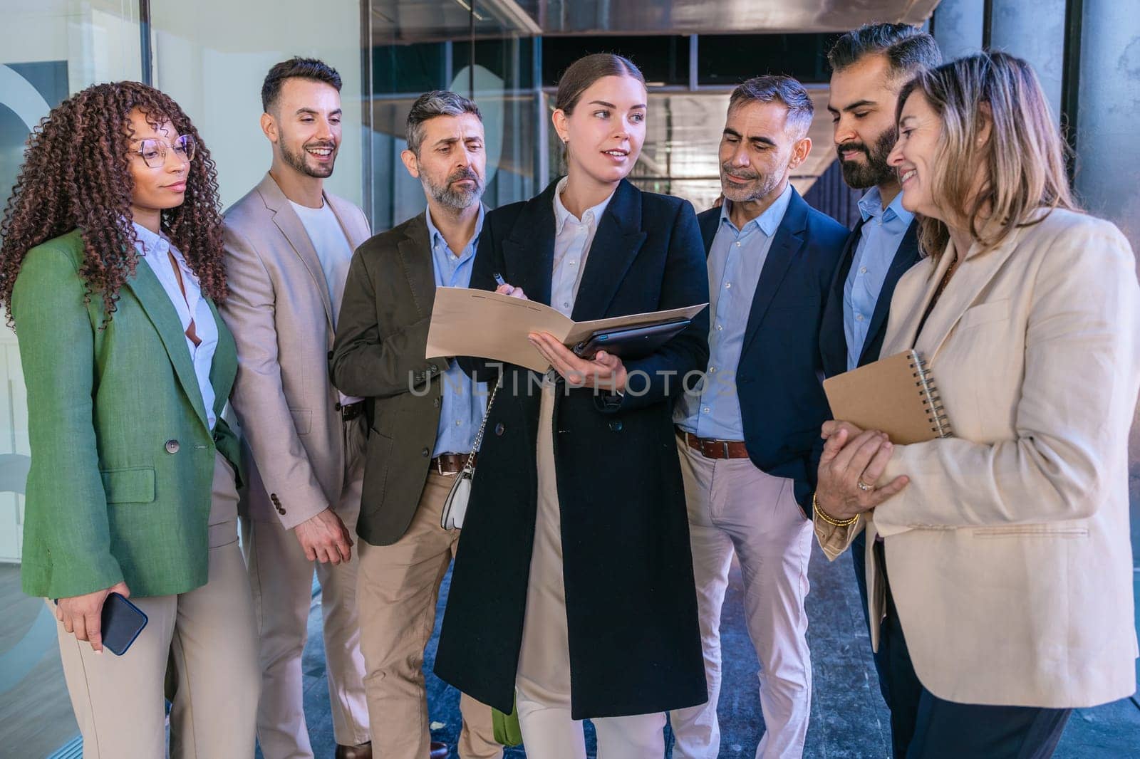 A diverse business team having a meeting and discussing ideas in a modern office. Professionals in formal attire collaborating with a notebook and tablet. Perfect for teamwork, business, and planning themes.