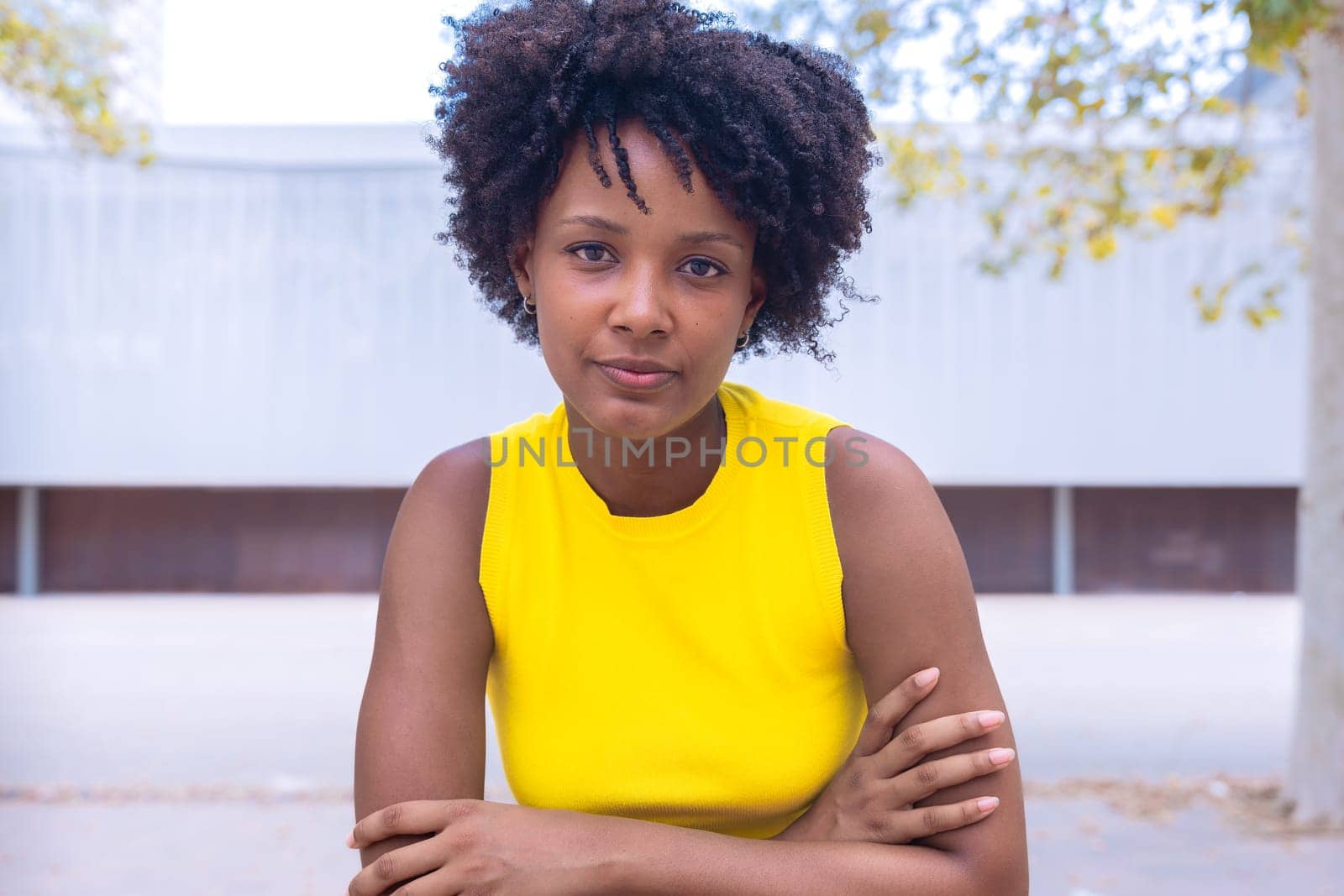 Portrait of black woman with a smiling, thoughtful expression. Focus on her facial features and natural beauty, captured outdoors with soft lighting and an urban background.