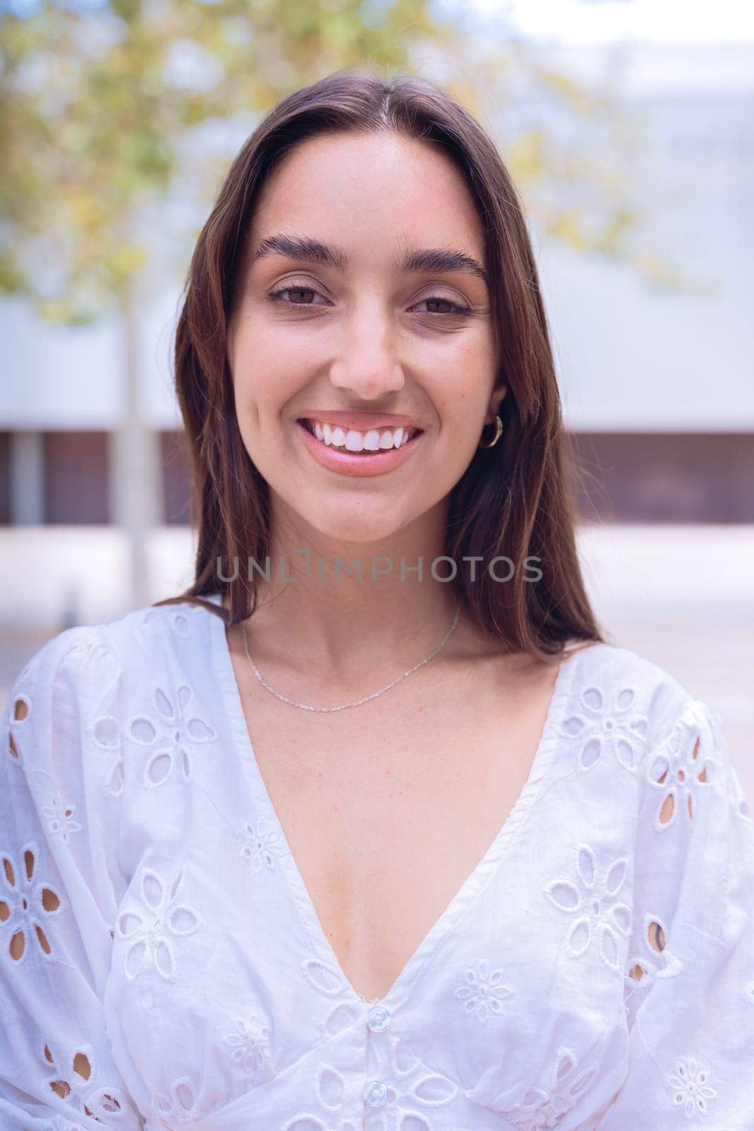 Portrait of woman with a smiling, Focus on her facial features and natural beauty, captured outdoors with soft lighting and an urban background.