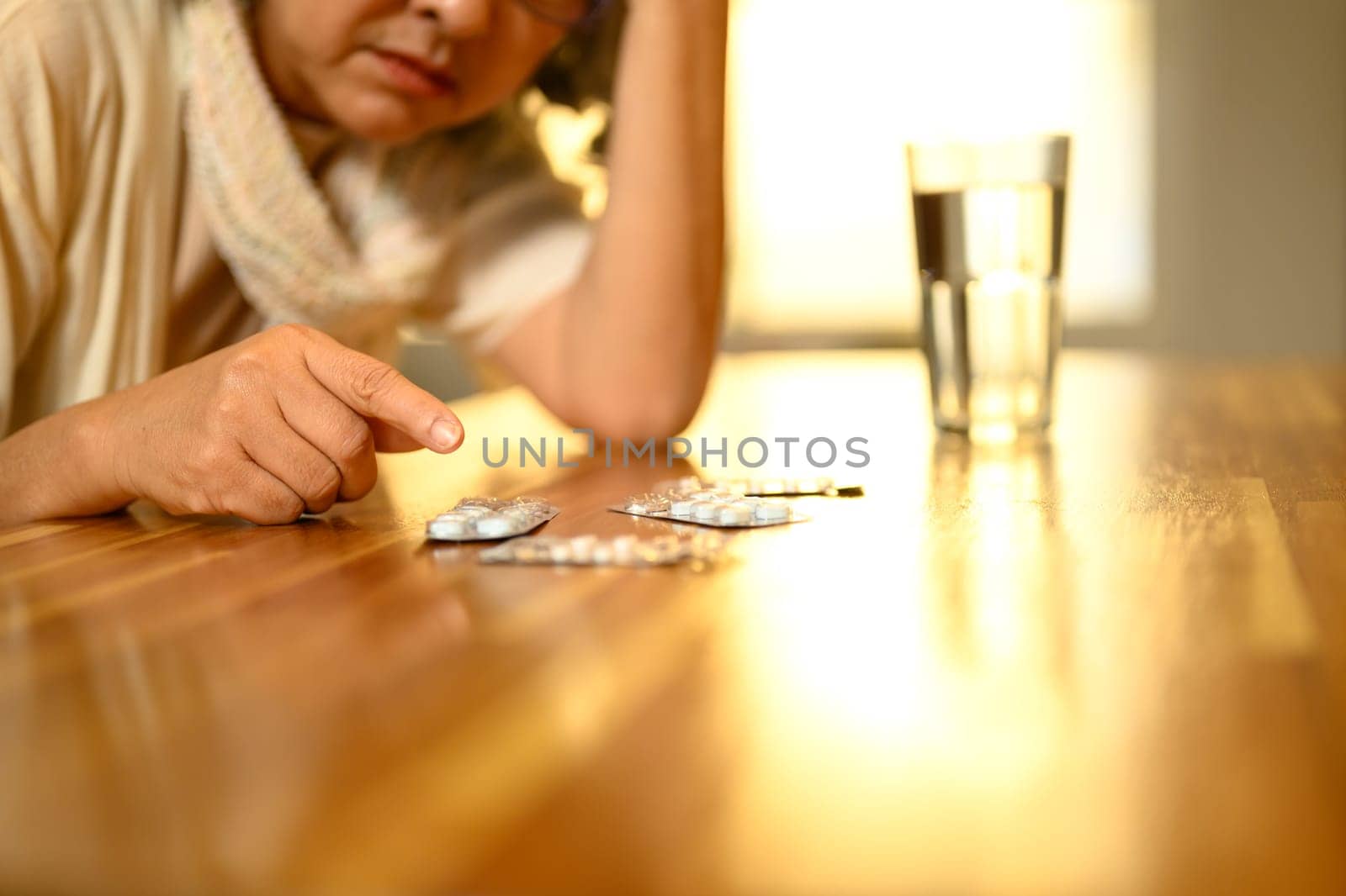 Cropped shot senior woman organizing or preparing to take her medication on a table..