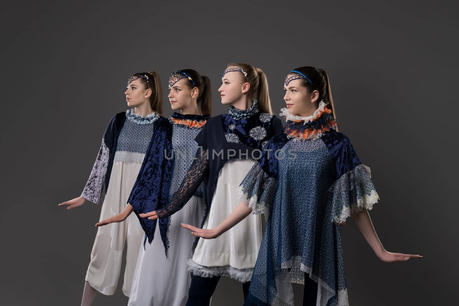 Shot of pretty girls in artistic design costumes view against gray background