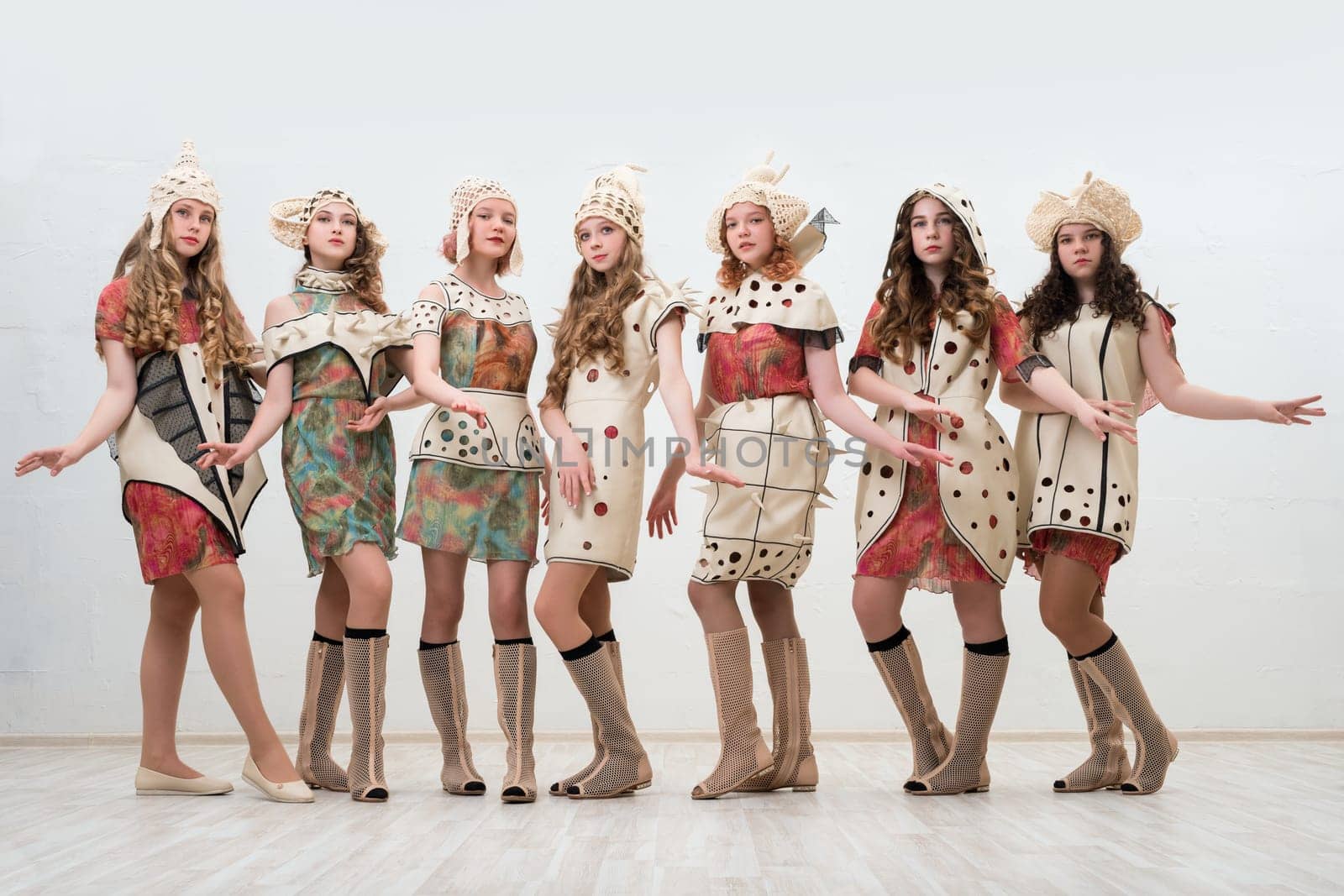 Pretty girls wearing fashion colorful dresses view against white wall