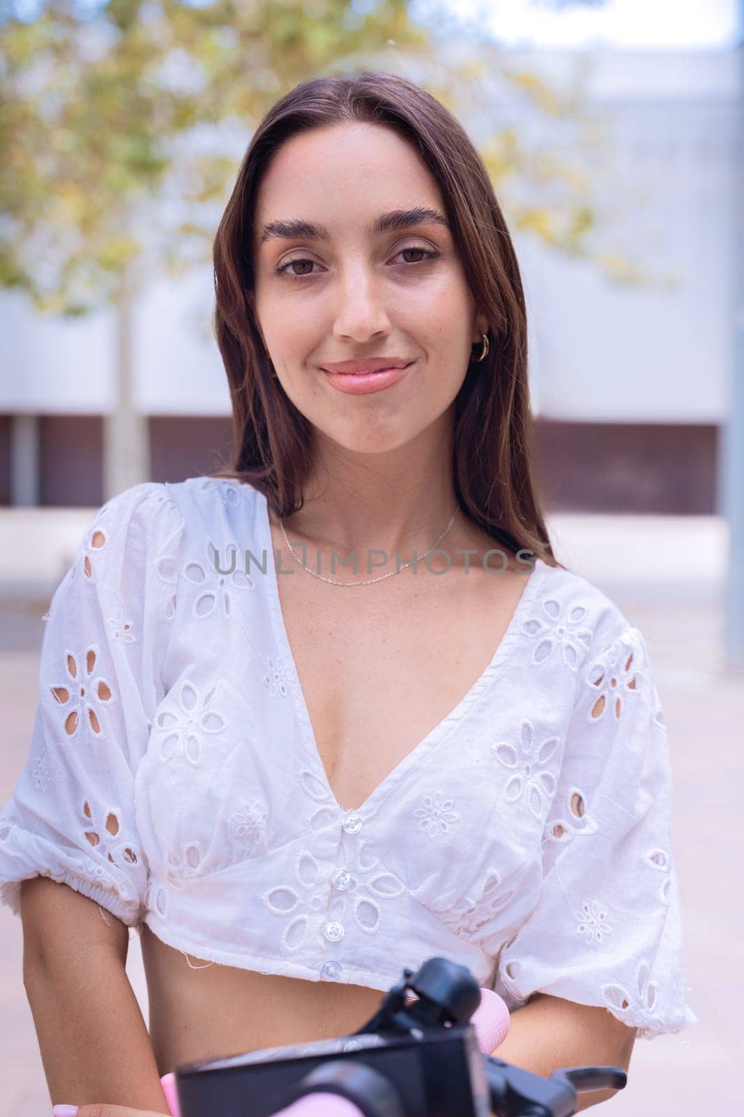 Portrait of woman with a smiling, Focus on her facial features and natural beauty, captured outdoors with soft lighting and an urban background.