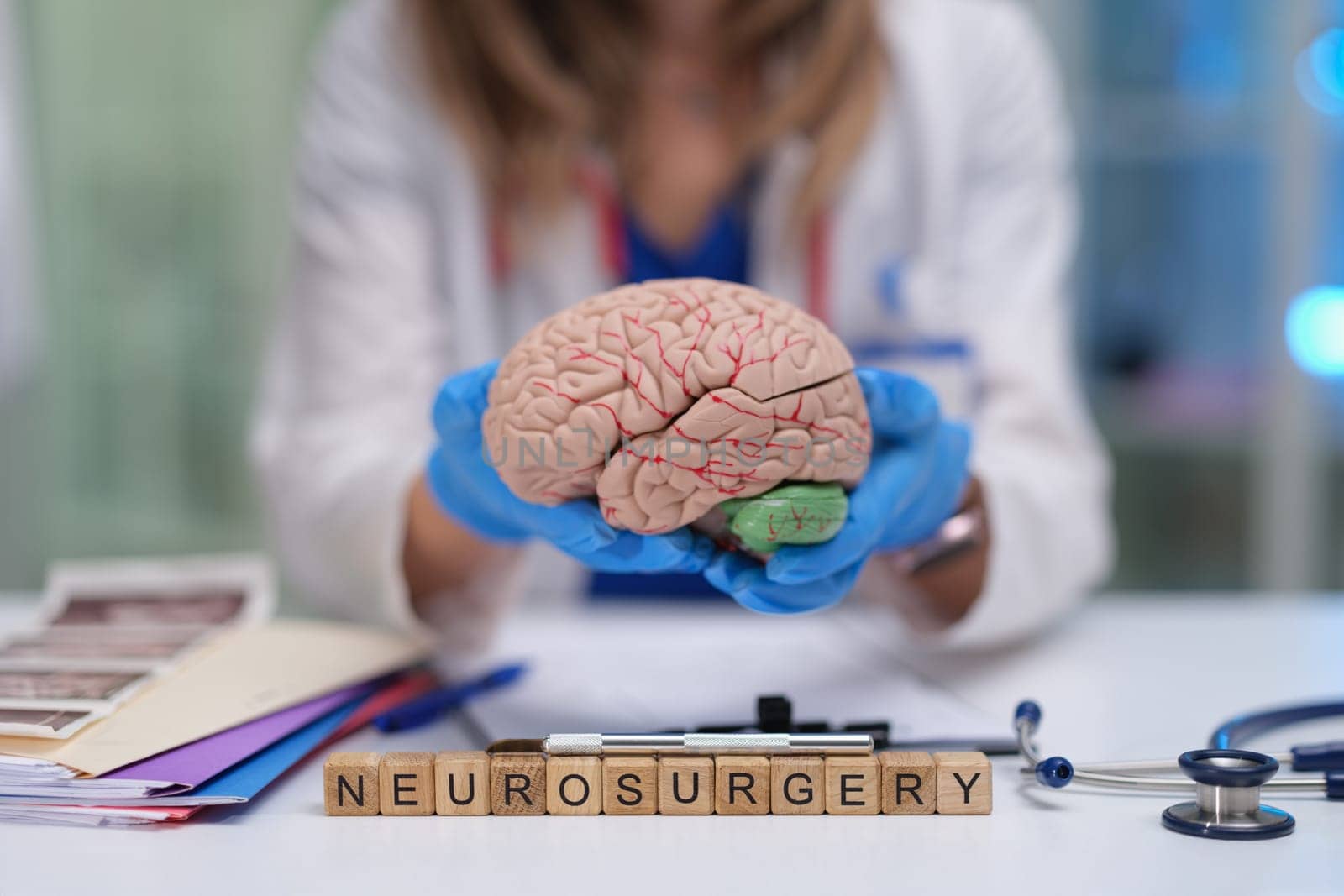 A trained medical professional presents a brain model, emphasizing the importance of neurosurgery education