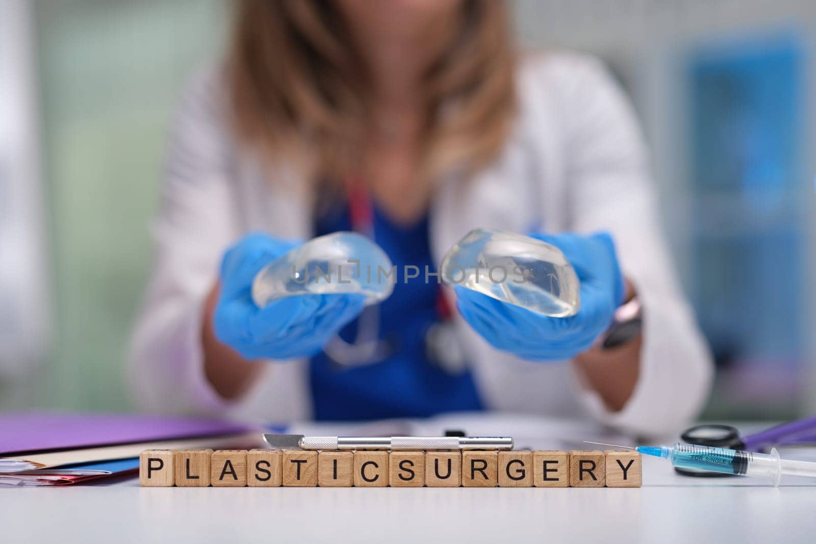 A plastic surgeon holds silicone implants in a clinical setting, emphasizing cosmetic surgery options.