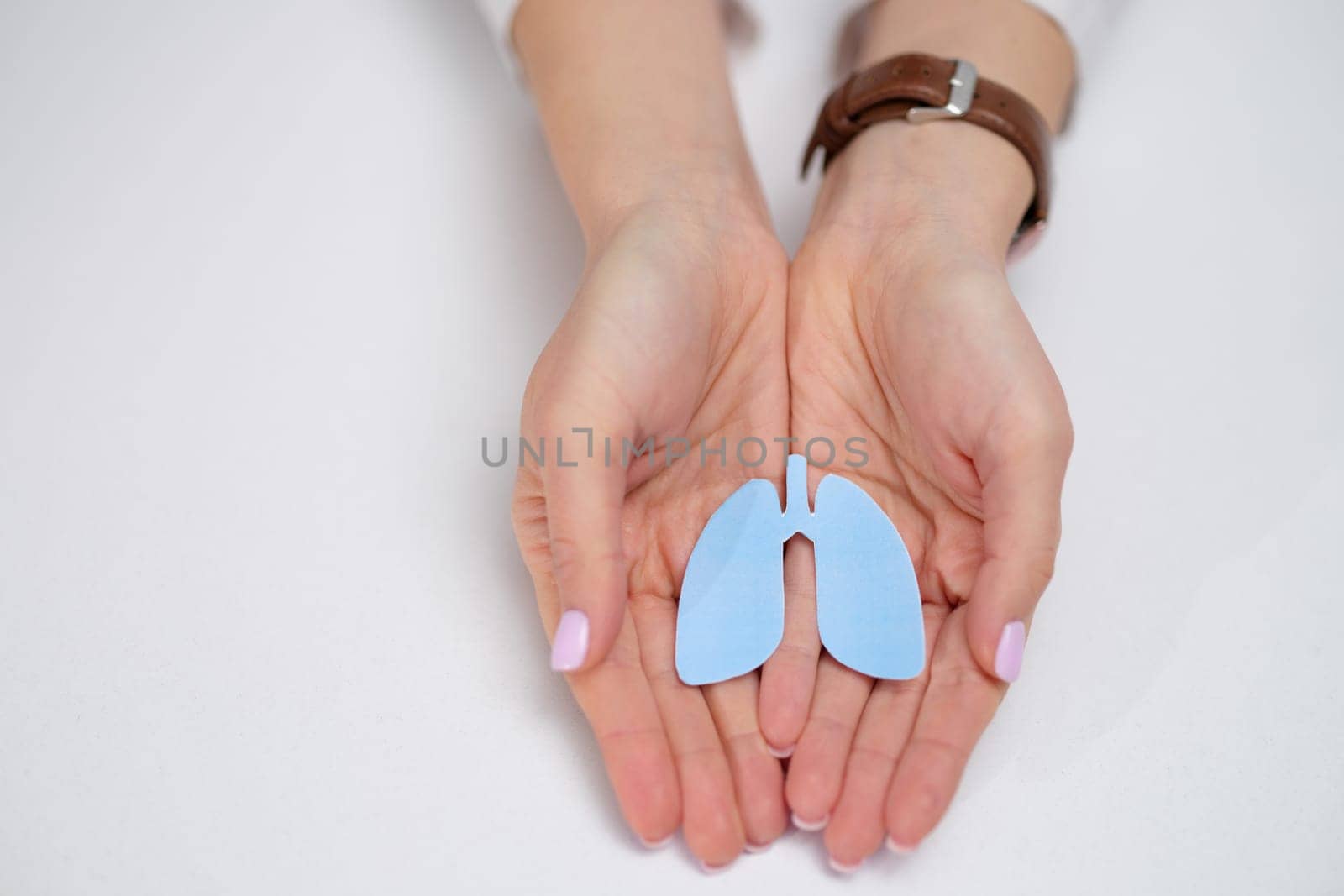 Closeup of hands holding a vibrant blue model of lungs, symbolizing health and respiratory awareness