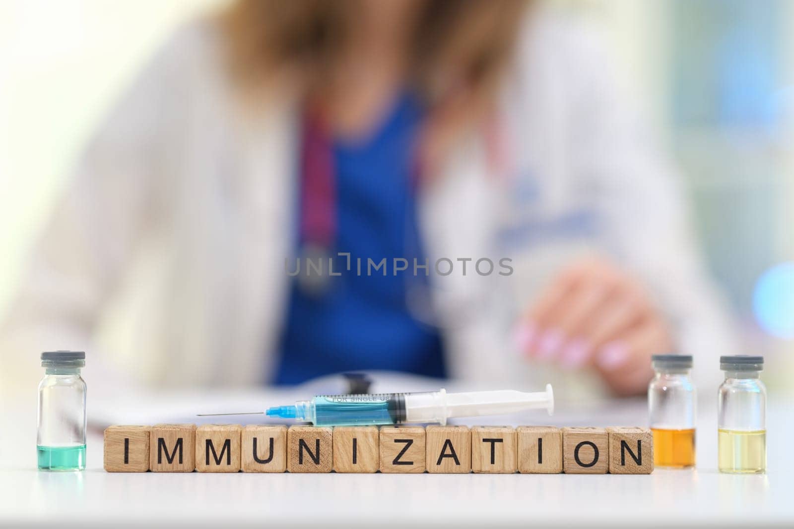 A healthcare worker organizes vaccine vials, spelling out immunization with building blocks to raise awareness