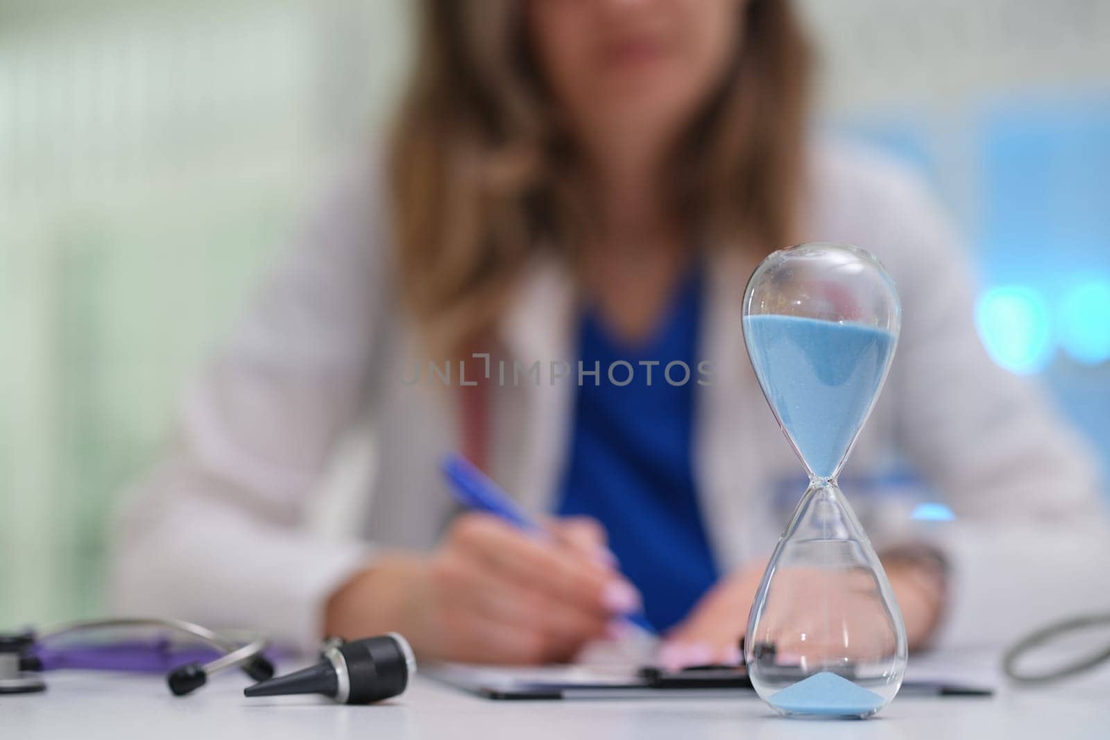A medical professional emphasizes time managements critical importance in healthcare while working with an hourglass
